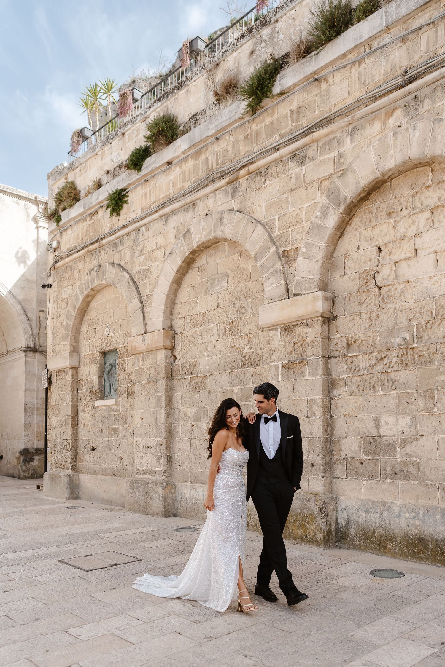 Walking through the streets of Matera with the arched walls for their relaxed wedding photos