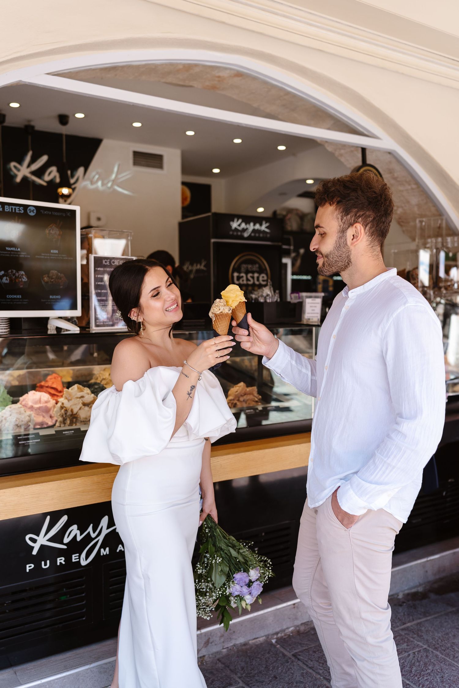 Wedding couple enjoying an Italian-style ice cream on Greek Wedding Day. Crete Photographer