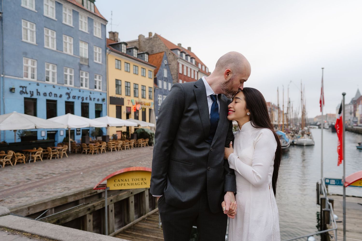 Newlyweds walking along Nyhavn Canal in Copenhagen. Denmark wedding. Scandinavian & Destination Wedding Photographer