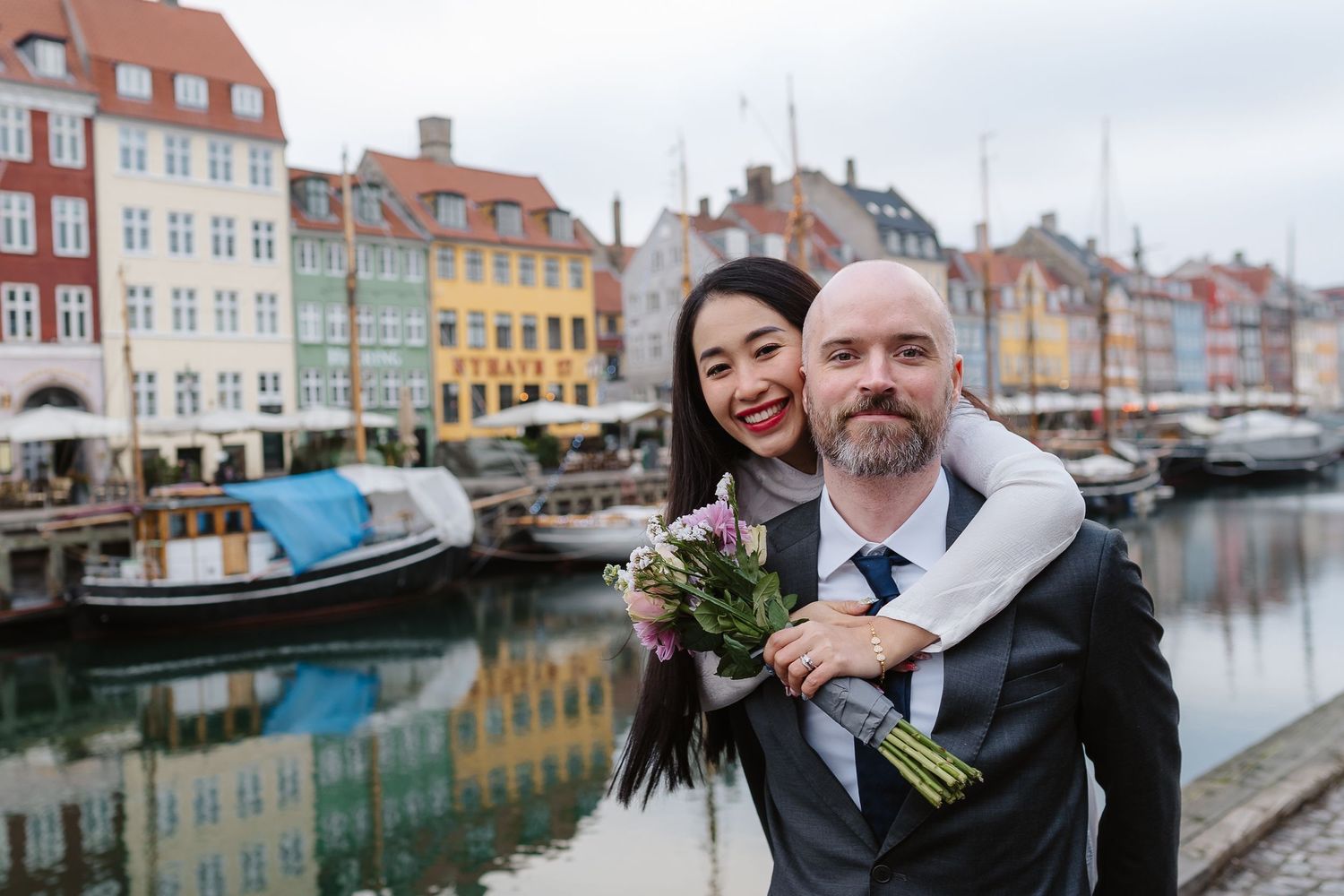 Newlyweds walking along Nyhavn Canal in Copenhagen. Denmark wedding. Scandinavian & Destination Wedding Photographer
