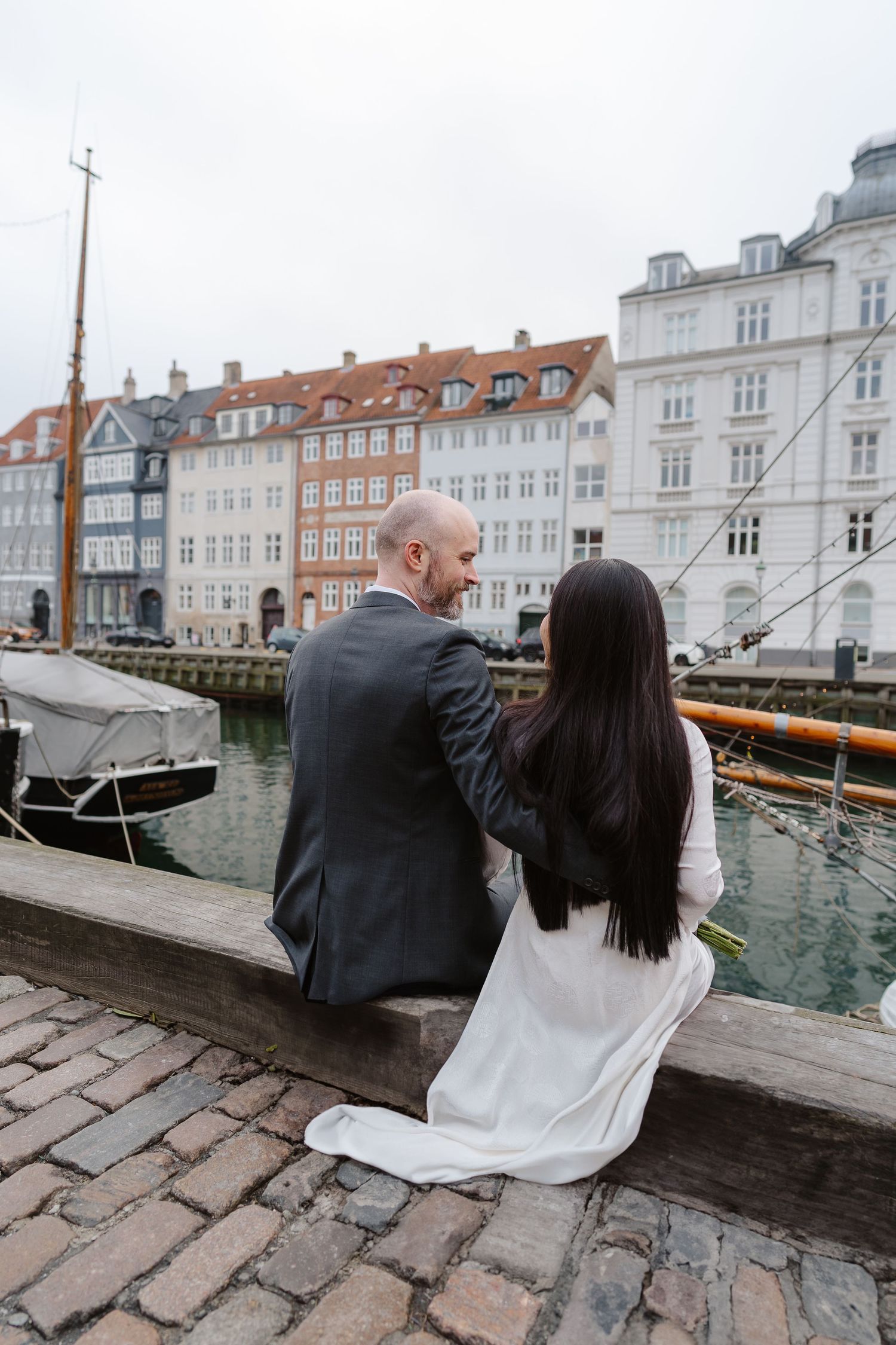 Newlyweds walking along Nyhavn Canal in Copenhagen. Denmark wedding. Scandinavian & Destination Wedding Photographer