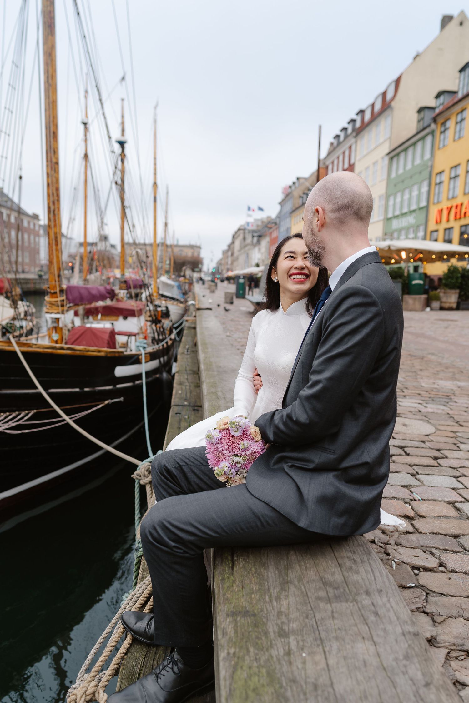 Newlyweds walking along Nyhavn Canal in Copenhagen. Denmark wedding. Scandinavian & Destination Wedding Photographer