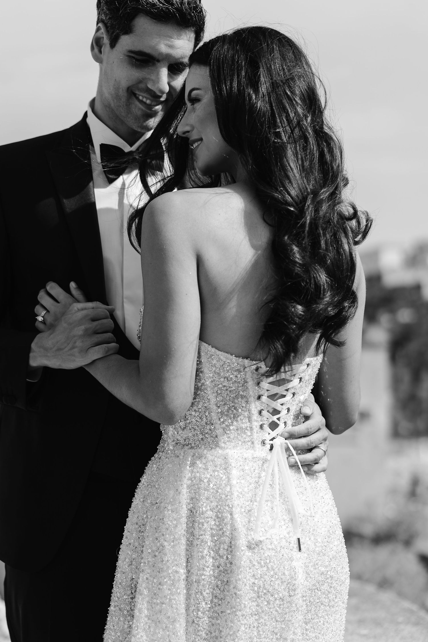 Black and White - Embracing couple - backless laced up luxury wedding dress