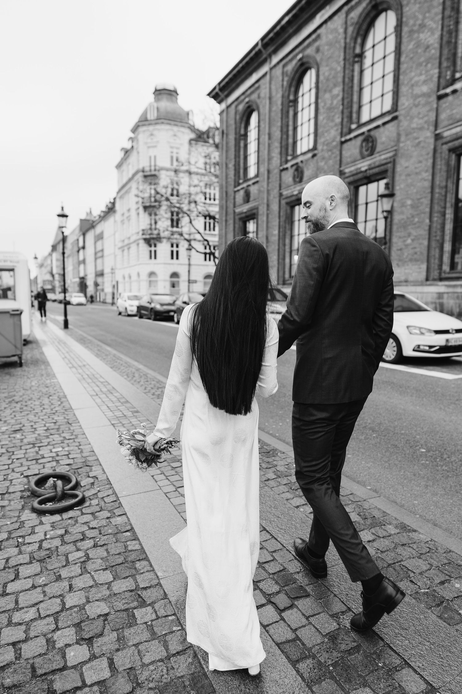 Newlyweds walking along Nyhavn Canal in Copenhagen. Denmark wedding. Scandinavian & Destination Wedding Photographer