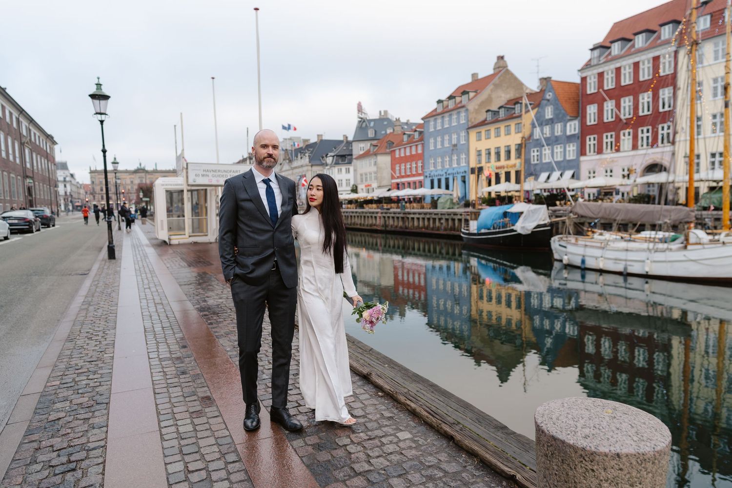 Newlyweds walking along Nyhavn Canal in Copenhagen. Denmark wedding. Scandinavian & Destination Wedding Photographer