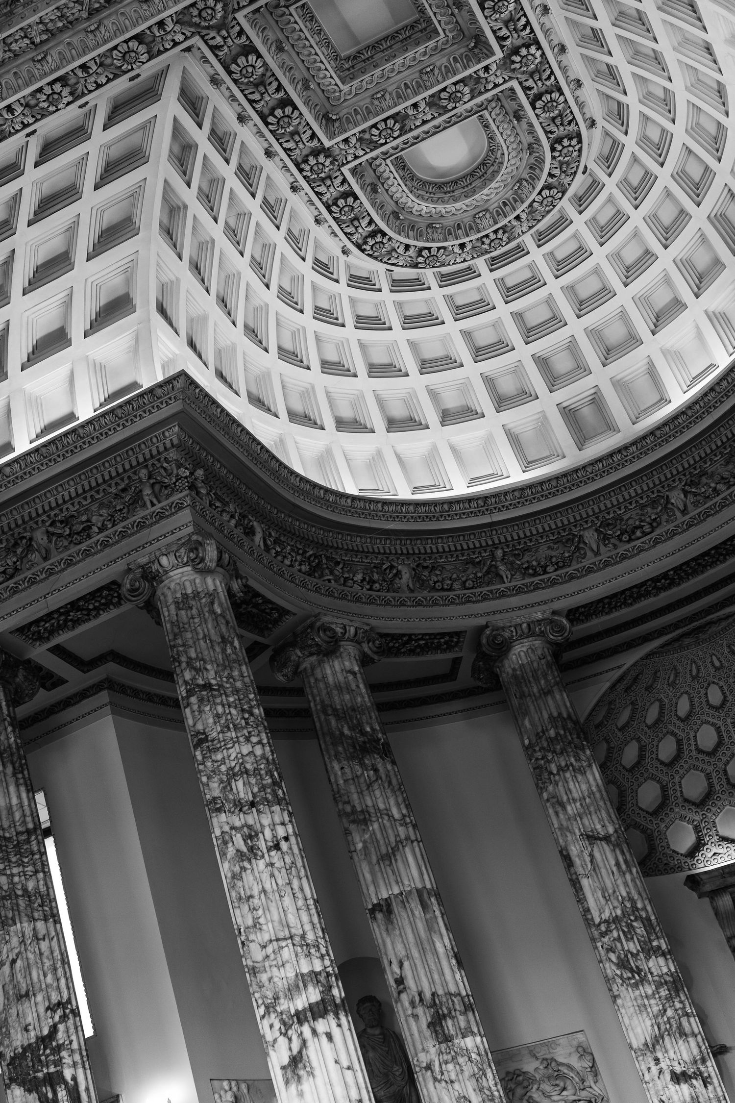 Black and white interior of a grand neoclassical dome with ornate coffered ceiling and tall marble columns.