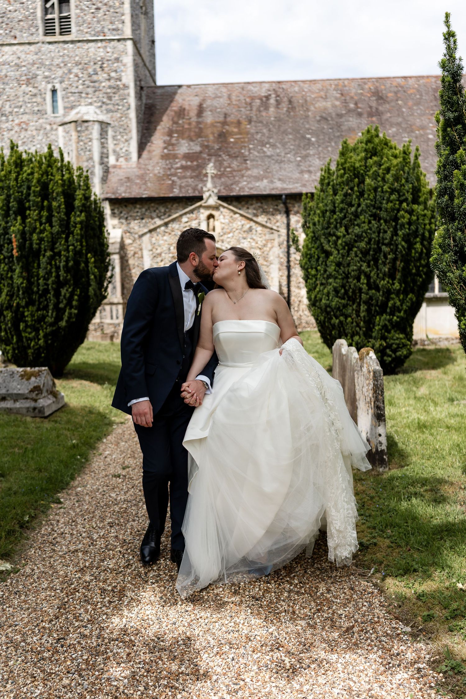 Romantic and fun couple walking out of the church on their Suffolk wedding day. Bright, effortless and elegantly photographed.