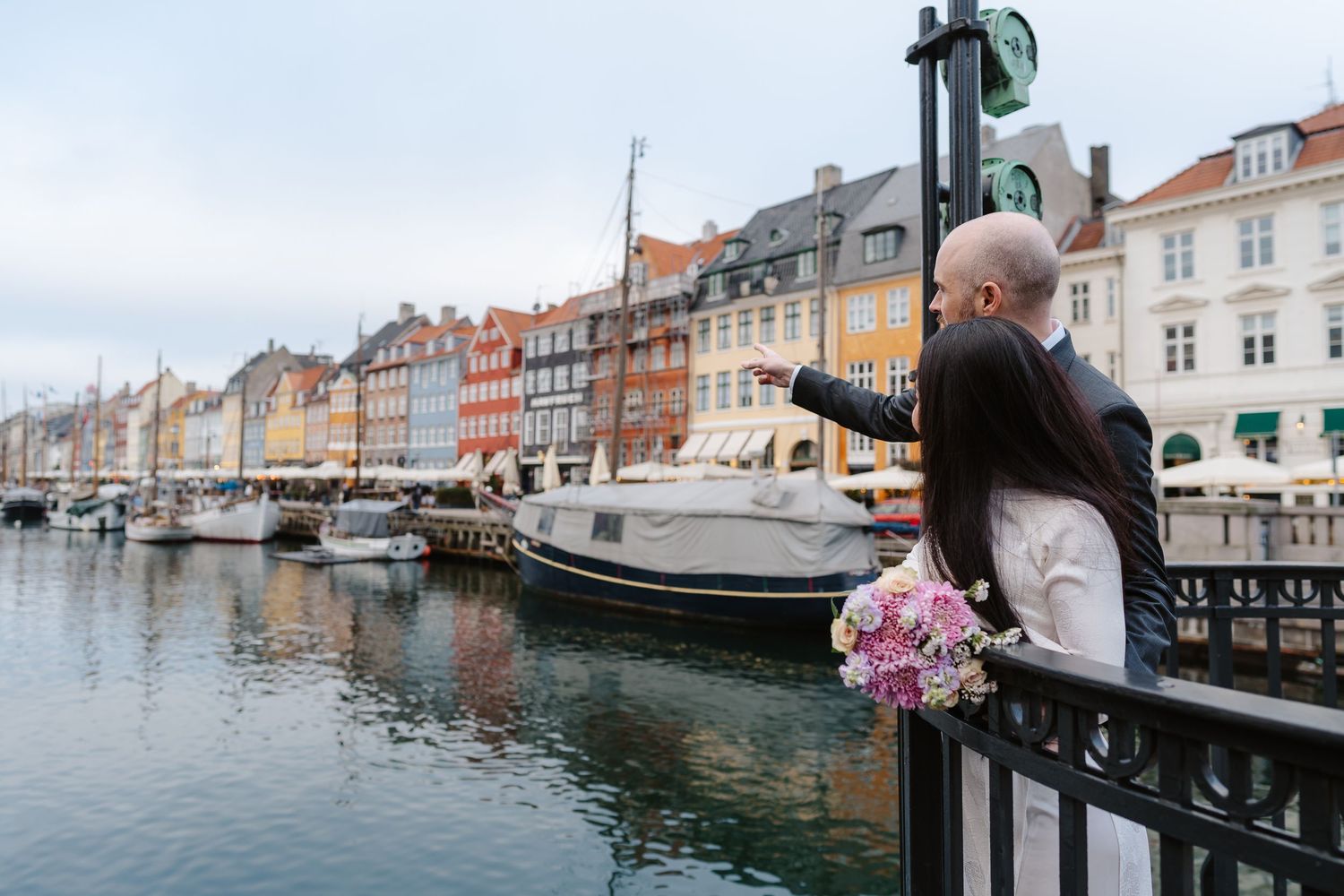 Newlyweds walking along Nyhavn Canal in Copenhagen. Denmark wedding. Scandinavian & Destination Wedding Photographer
