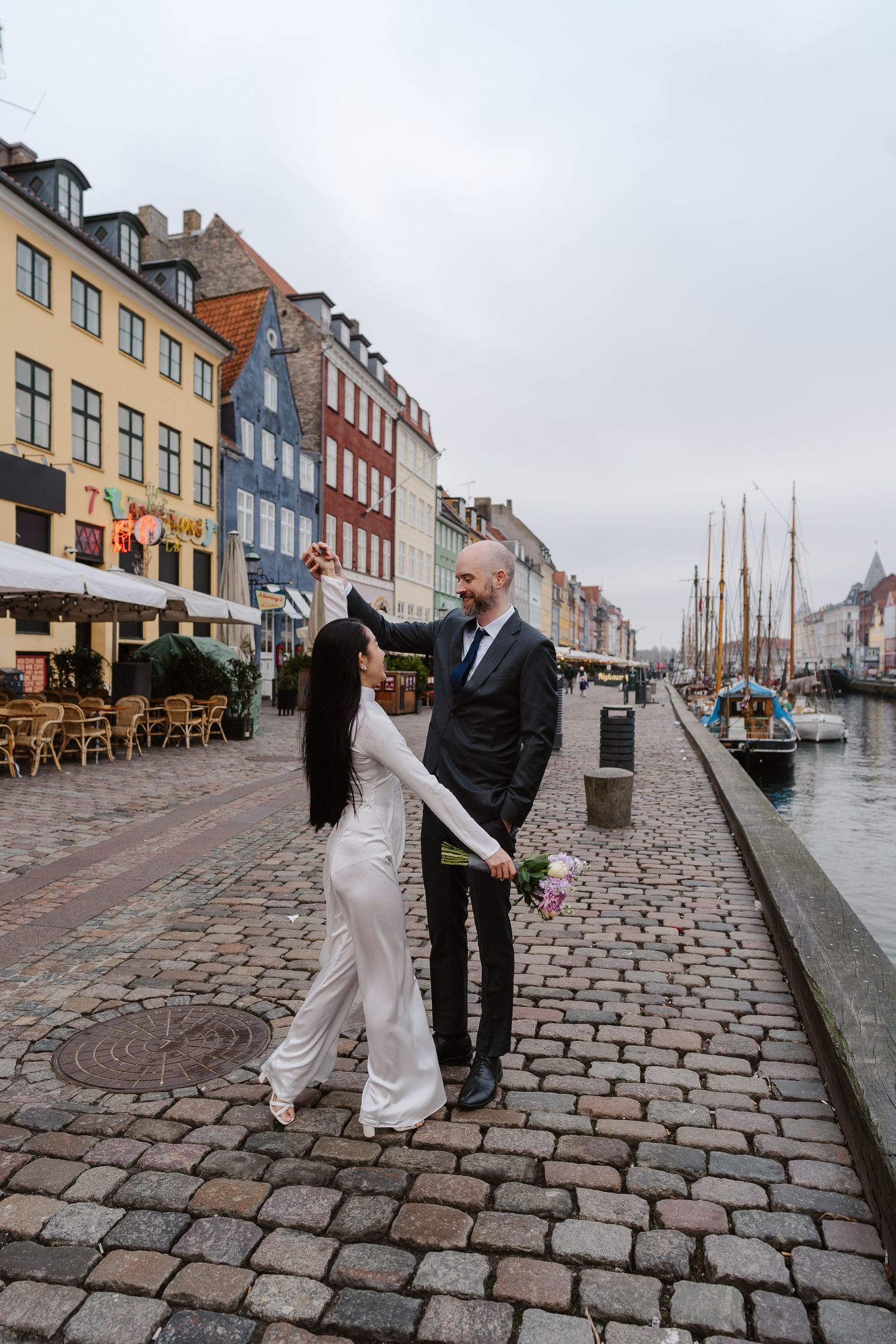 Newlyweds walking along Nyhavn Canal in Copenhagen. Denmark wedding. Scandinavian & Destination Wedding Photographer