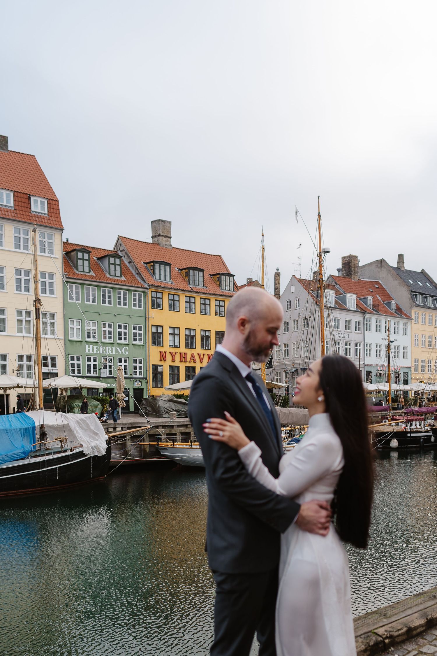 Newlyweds walking along Nyhavn Canal in Copenhagen. Denmark wedding. Scandinavian & Destination Wedding Photographer