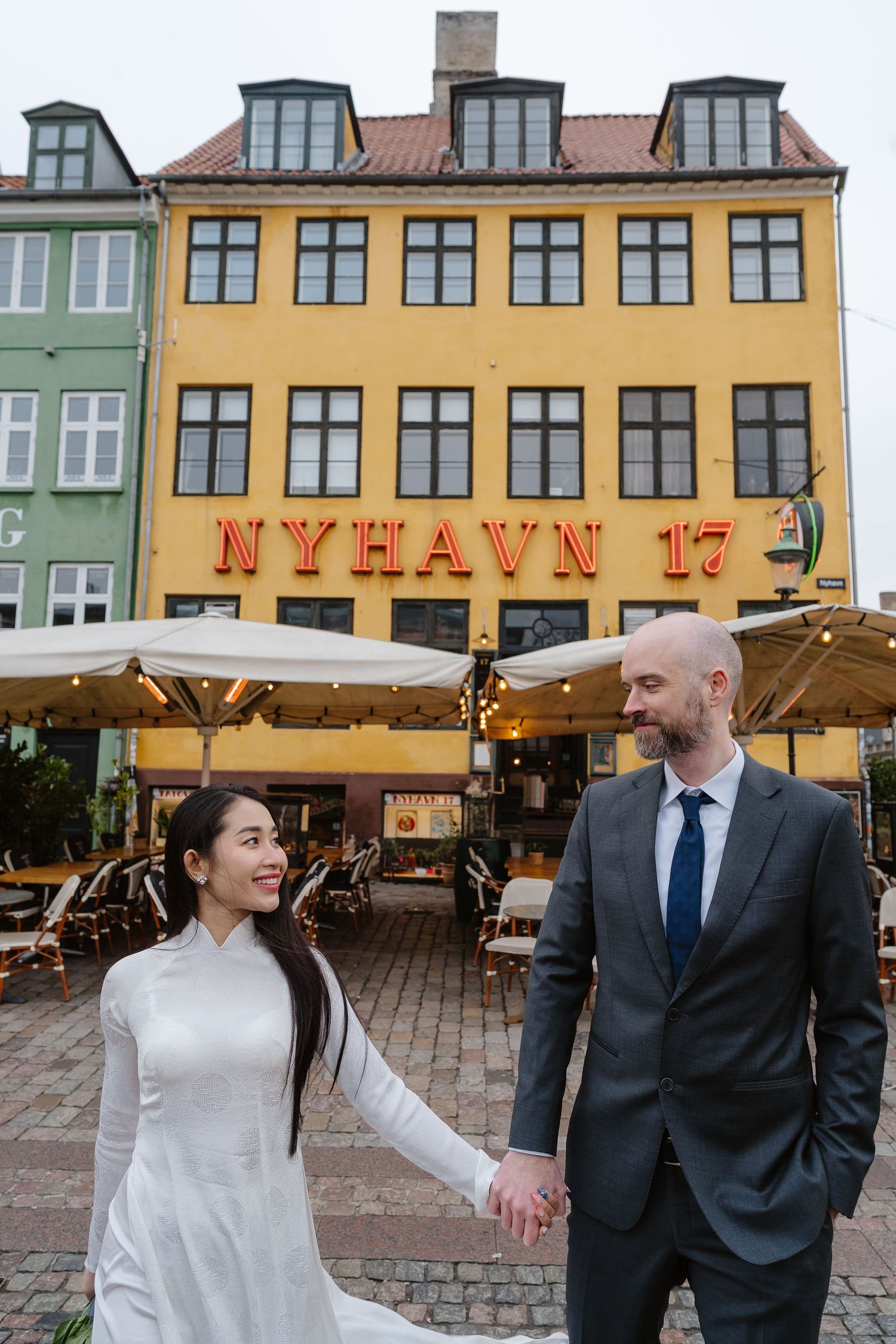 Newlyweds walking along Nyhavn Canal in Copenhagen. Denmark wedding. Scandinavian & Destination Wedding Photographer