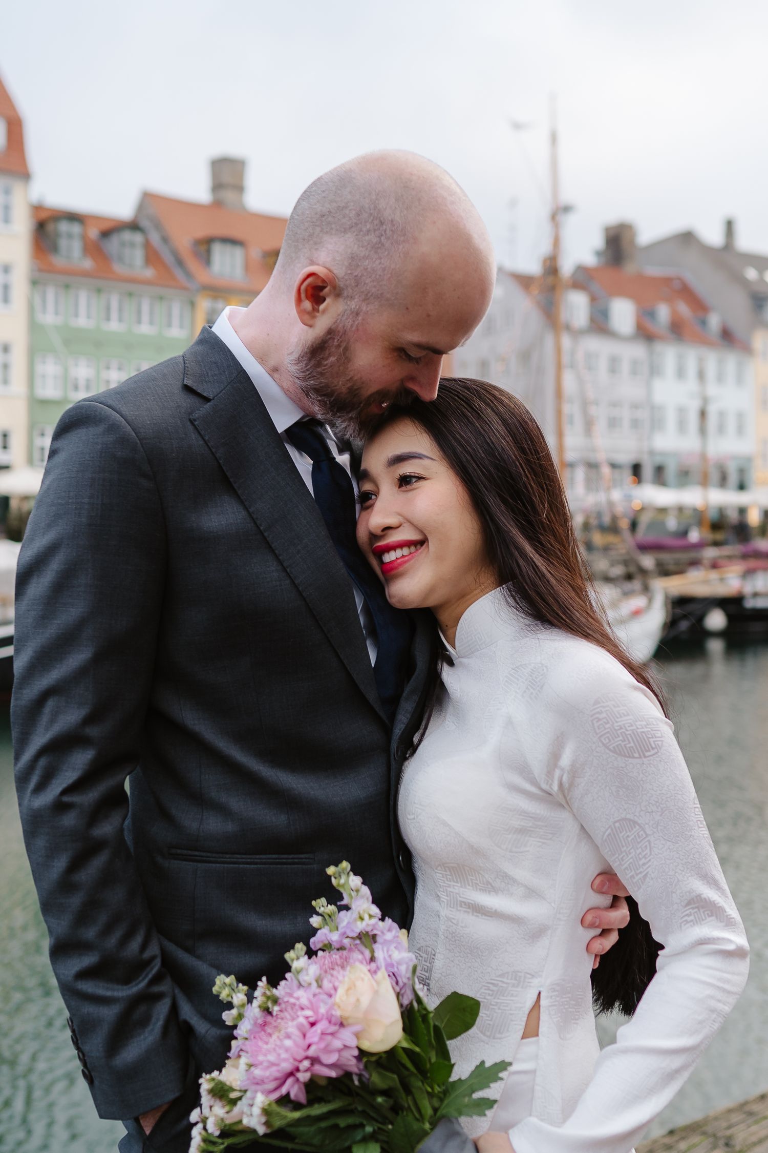 Newlyweds romance along Nyhavn Canal in Copenhagen. Denmark wedding. Scandinavian & Destination Wedding Photographer