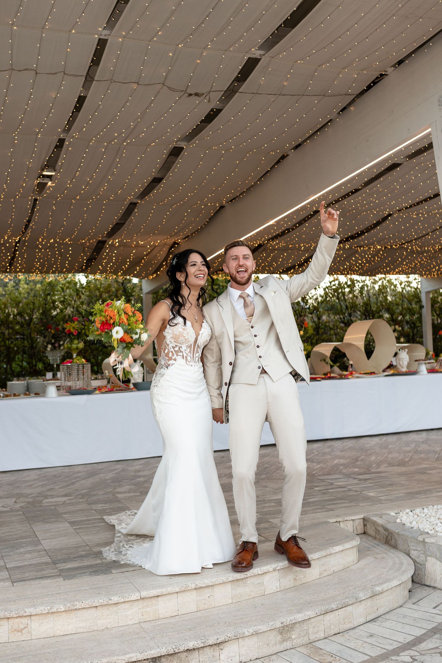 Joyful bride and groom celebrating their wedding reception entrance at Luxor Park wedding venue in the heart of Sicily, Italy