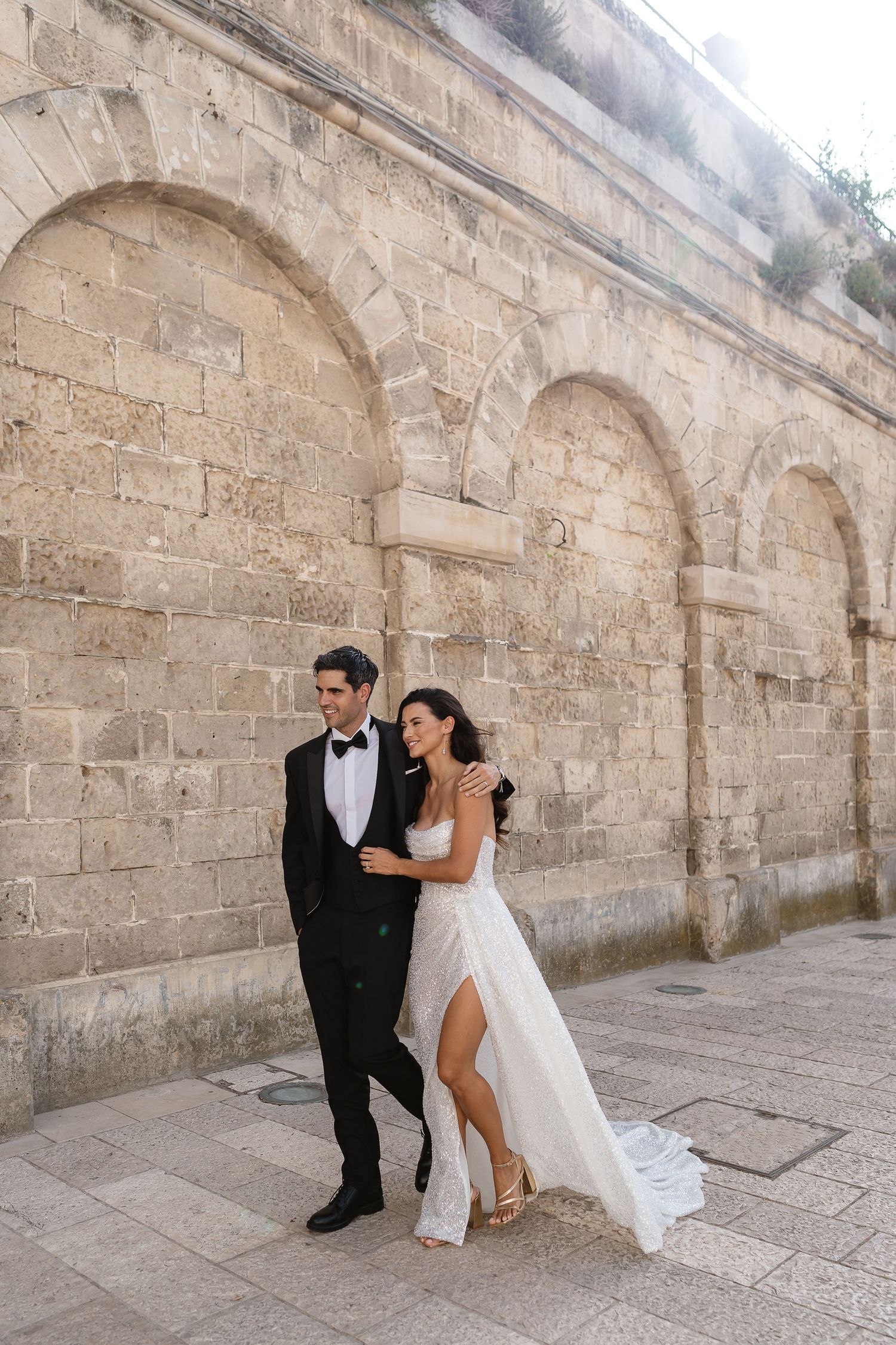 Walking through the streets of Matera with the arched walls for their relaxed wedding photos