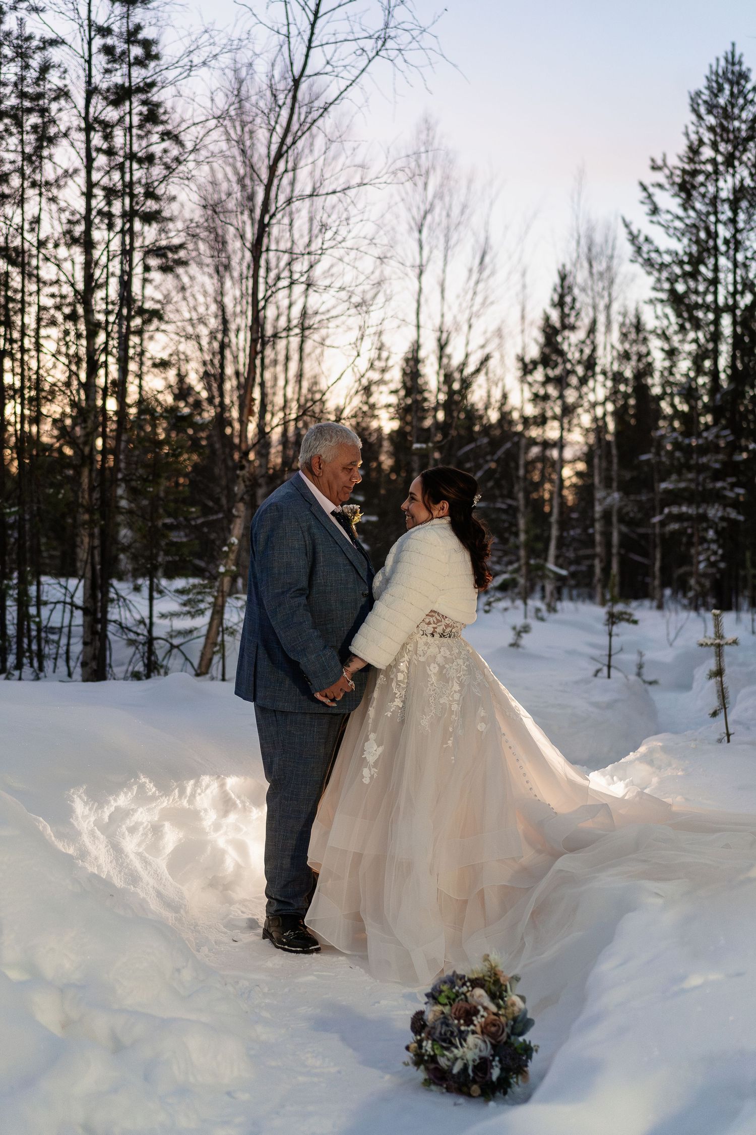 Couple candidly walking through forest at Twilight hour. Luxury Lapland wedding photographer. Snow wedding. Lapland wedding photos.