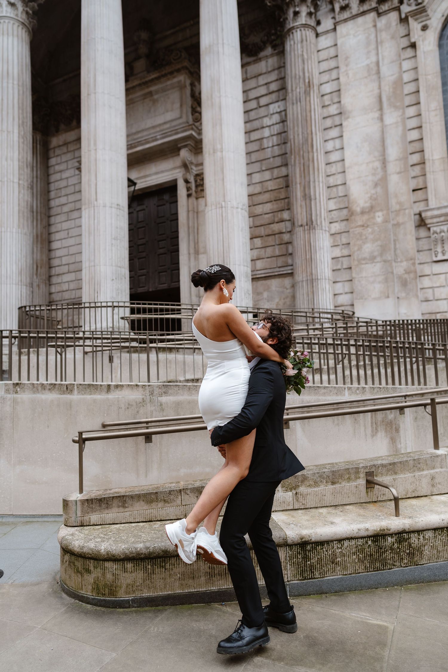 Luxury Bride & Groom walking past St Paul's Cathedral in London on wedding elopement. Wedding photographer