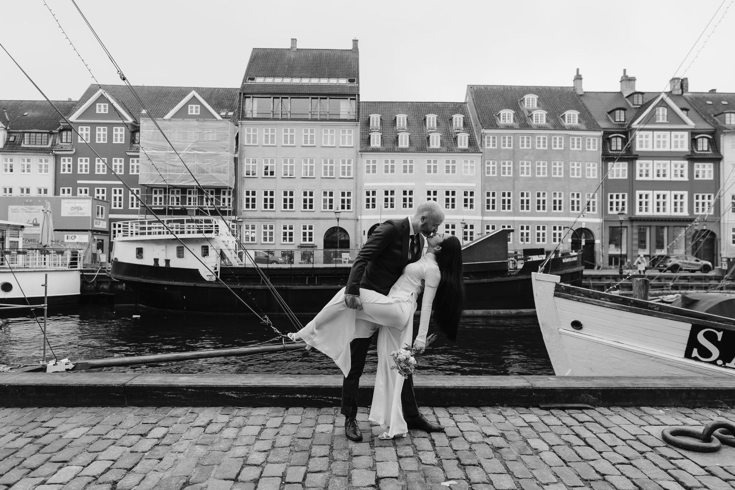 Newlyweds fun along Nyhavn Canal in Copenhagen. Denmark wedding. Scandinavian & Destination Wedding Photographer