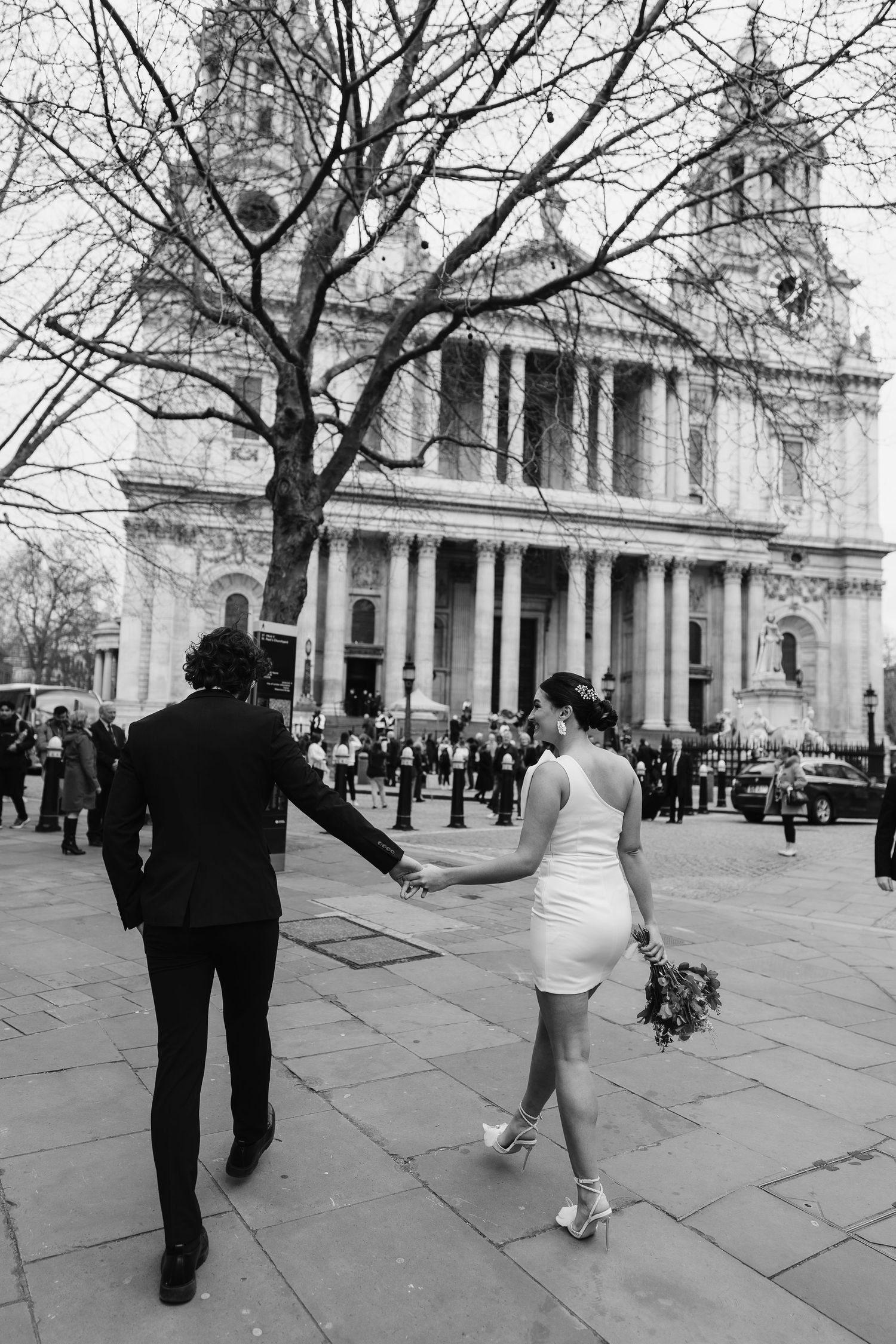 Luxury Bride & Groom walking past St Paul's Cathedral in London on wedding elopement. Wedding photographer