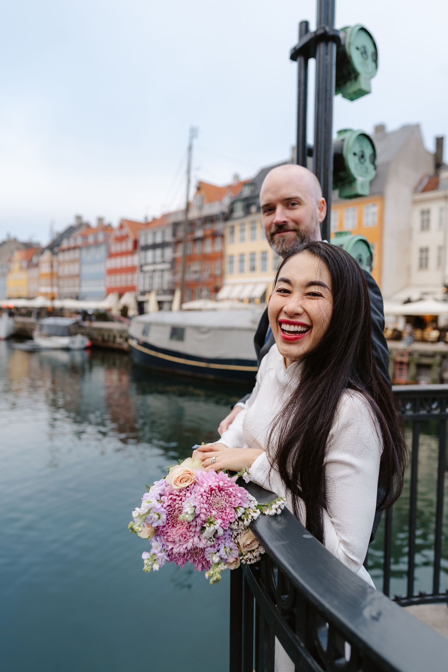Newlyweds walking along Nyhavn Canal in Copenhagen. Denmark wedding. Scandinavian & Destination Wedding Photographer