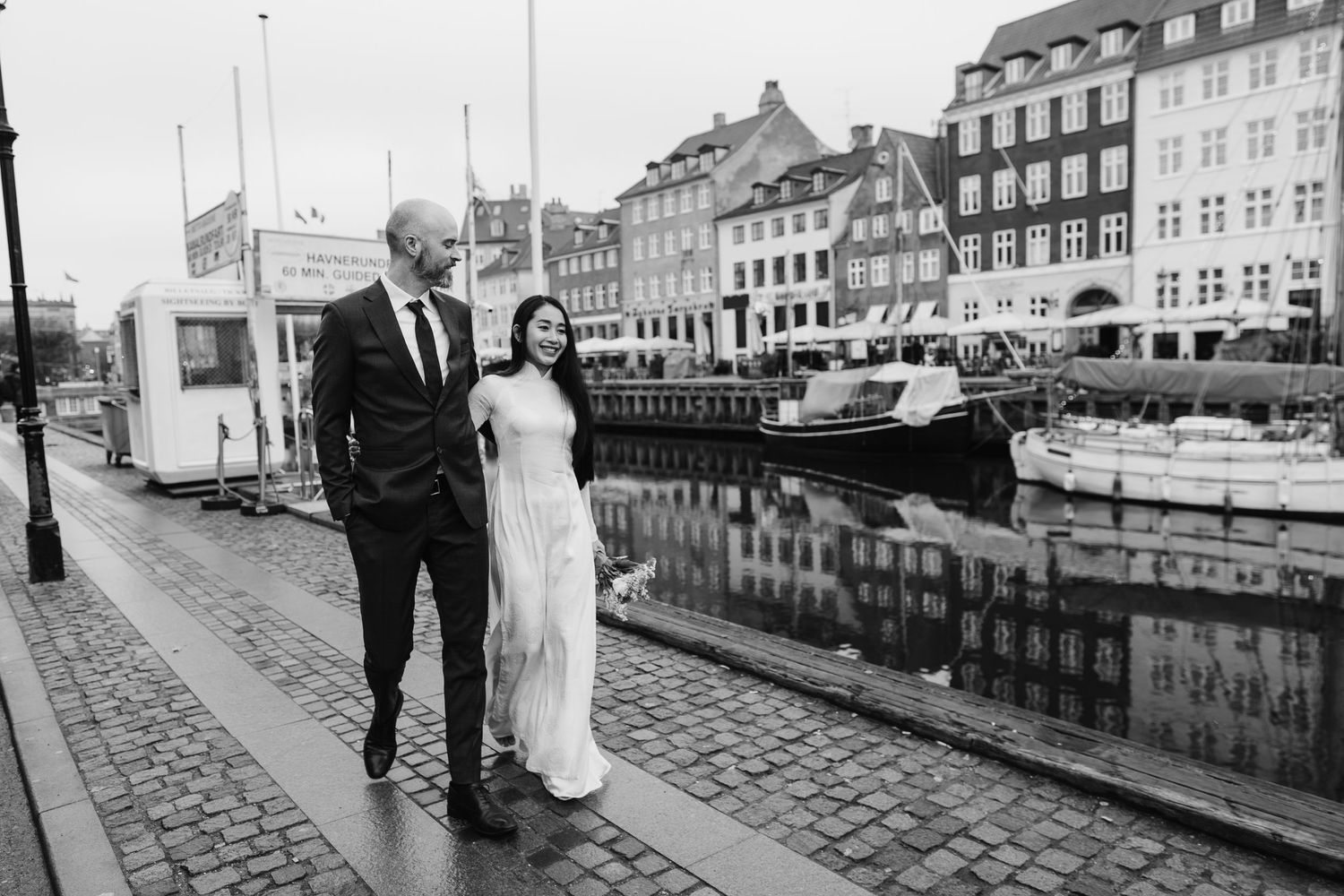 Newlyweds walking along Nyhavn Canal in Copenhagen. Denmark wedding. Scandinavian & Destination Wedding Photographer