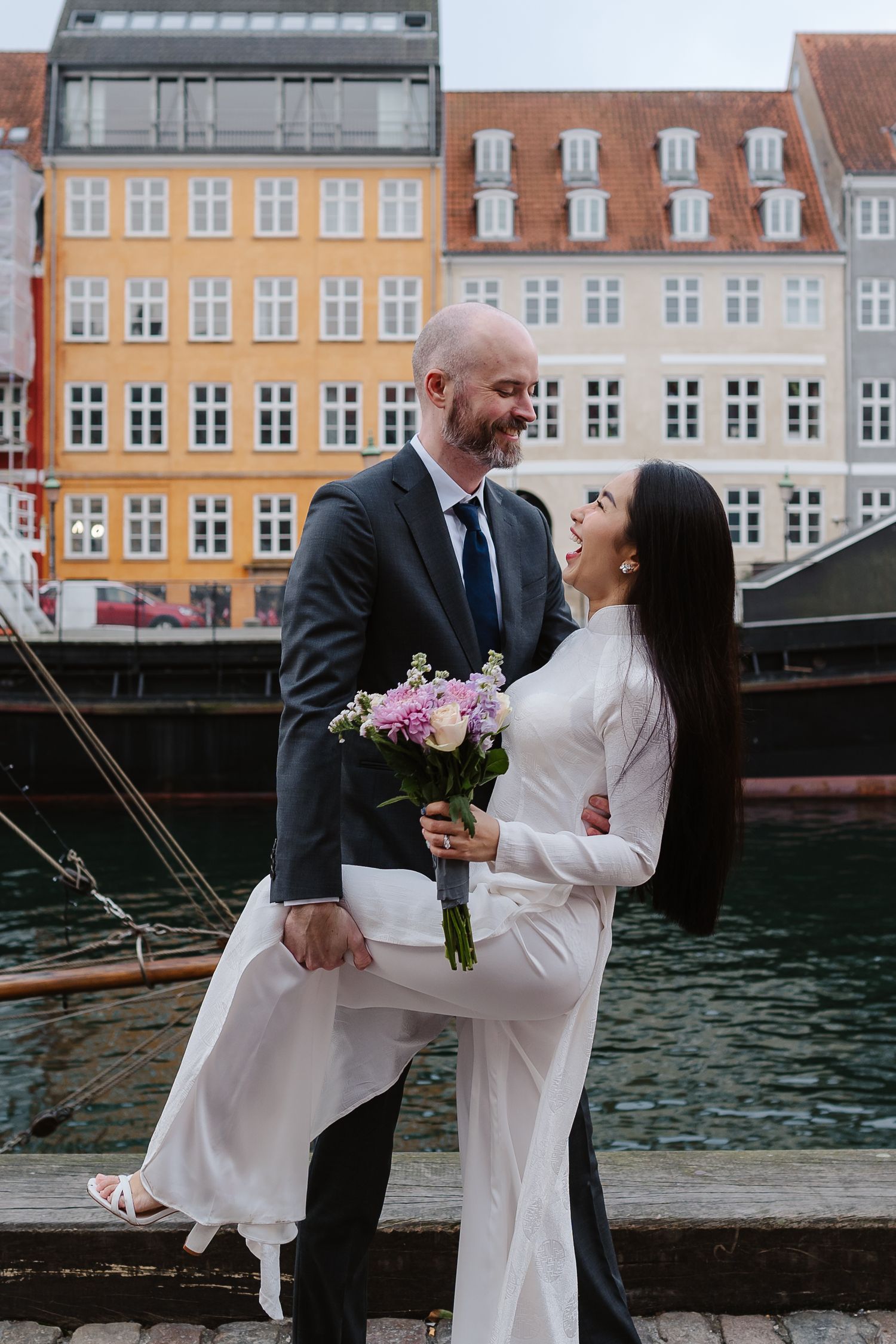 Newlyweds walking along Nyhavn Canal in Copenhagen. Denmark wedding. Scandinavian & Destination Wedding Photographer