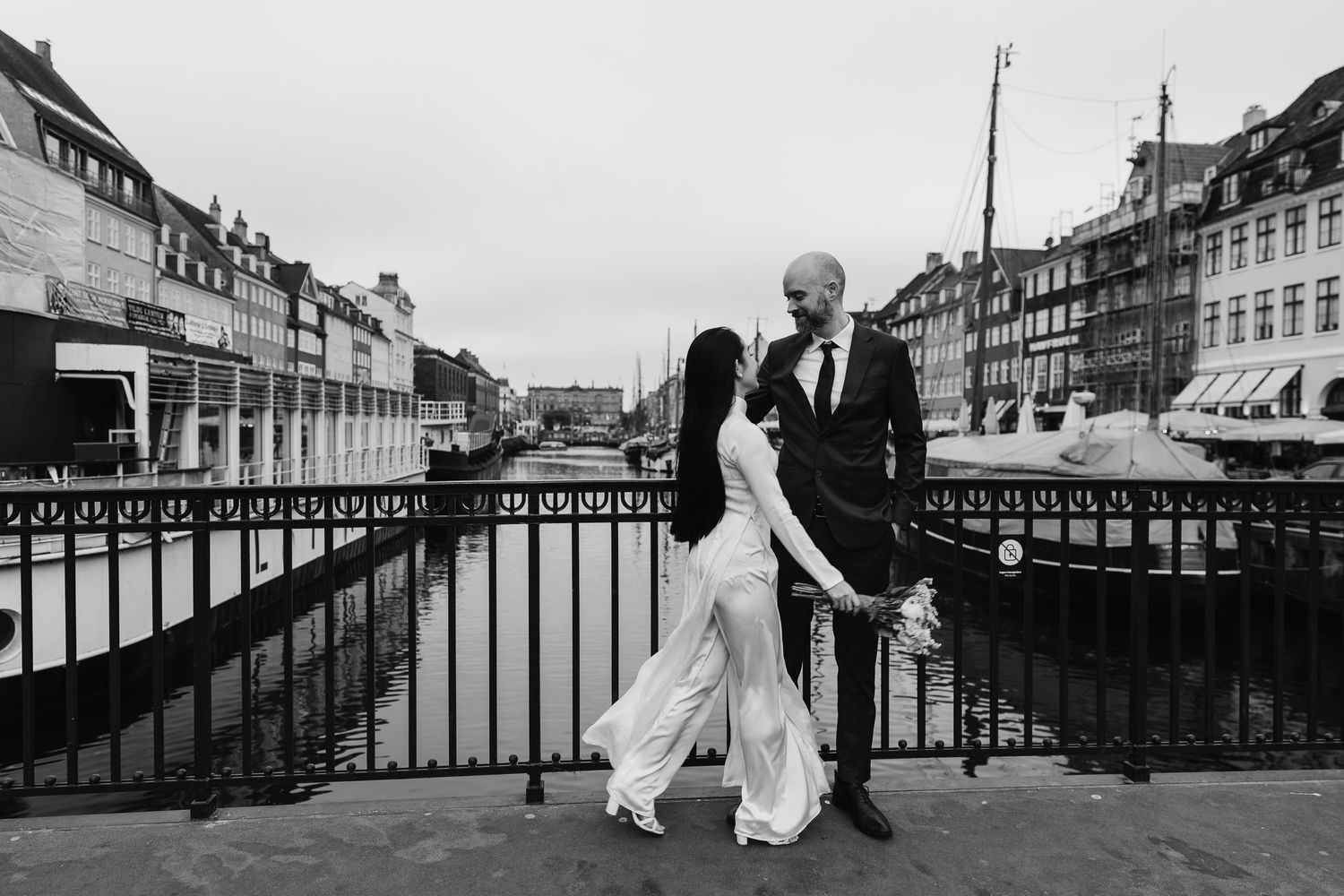 Newlyweds walking along Nyhavn Canal in Copenhagen. Denmark wedding. Scandinavian & Destination Wedding Photographer