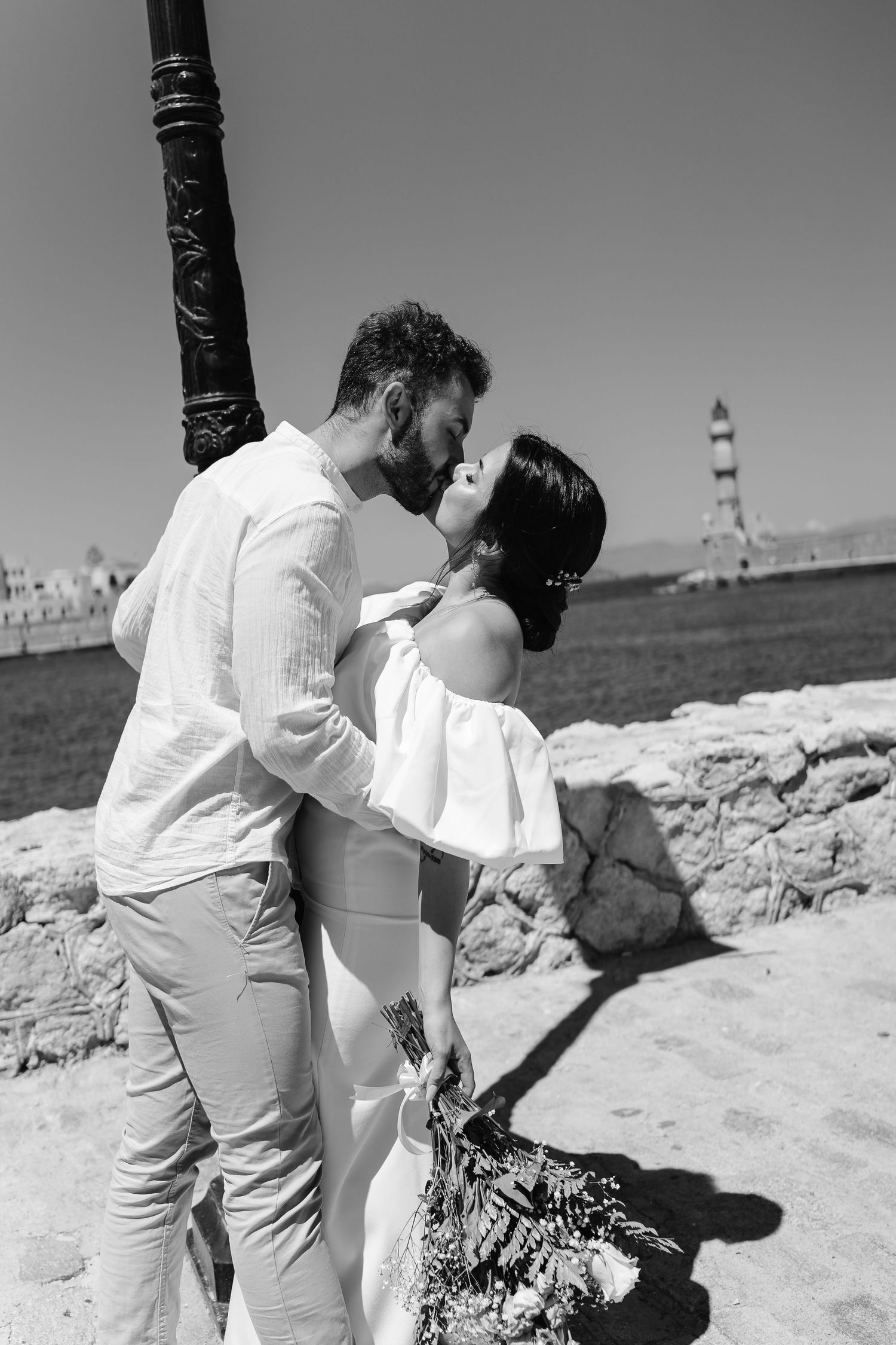 Couple kissing in front of Chania light house at Venetian Harbour by Crete wedding photographer