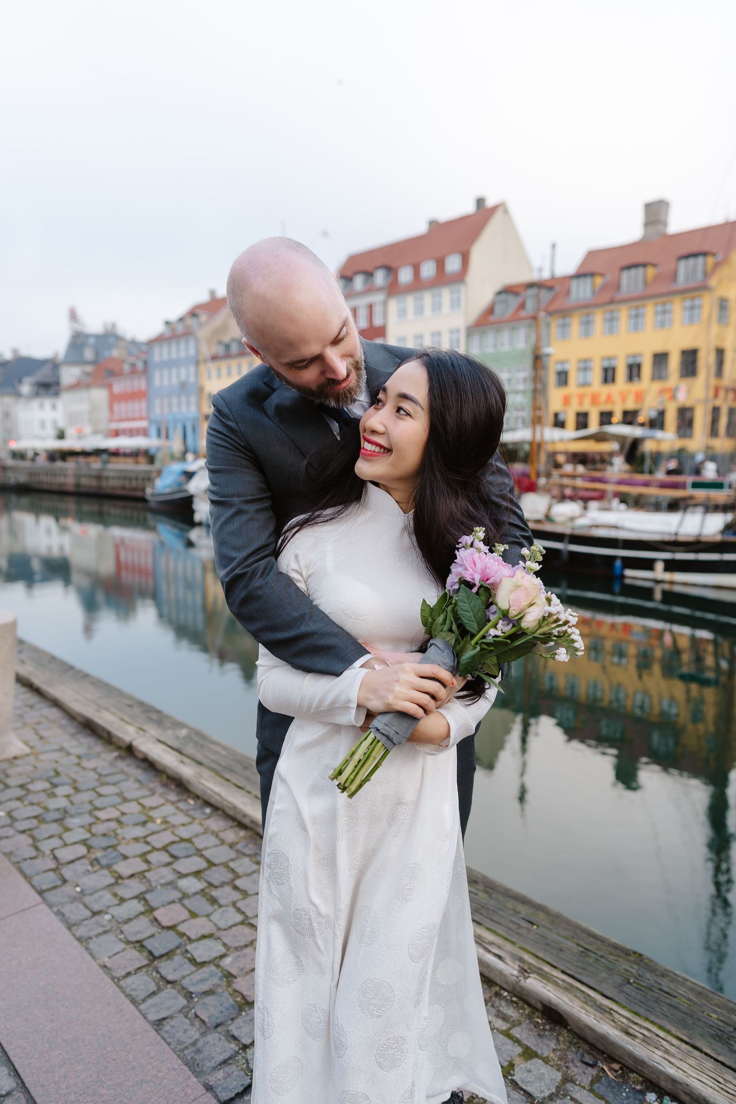 Newlyweds walking along Nyhavn Canal in Copenhagen. Denmark wedding. Scandinavian & Destination Wedding Photographer