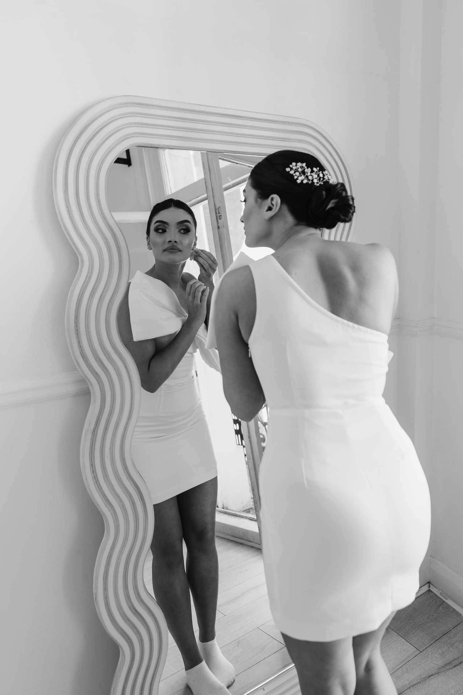 WEDDING DETAILS. Bride putting earrings in mirror. London St Paul's for London Weddin