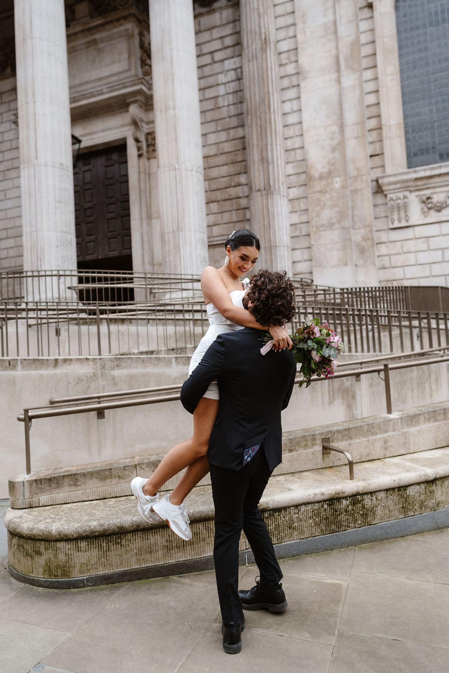 Luxury Bride & Groom walking past St Paul's Cathedral in London on wedding elopement. Wedding photographer