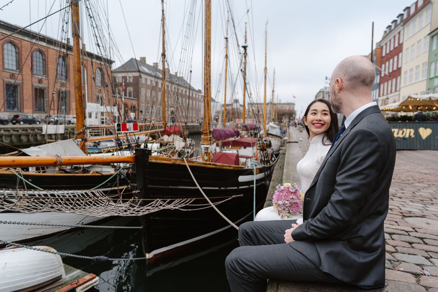 Newlyweds walking along Nyhavn Canal in Copenhagen. Denmark wedding. Scandinavian & Destination Wedding Photographer