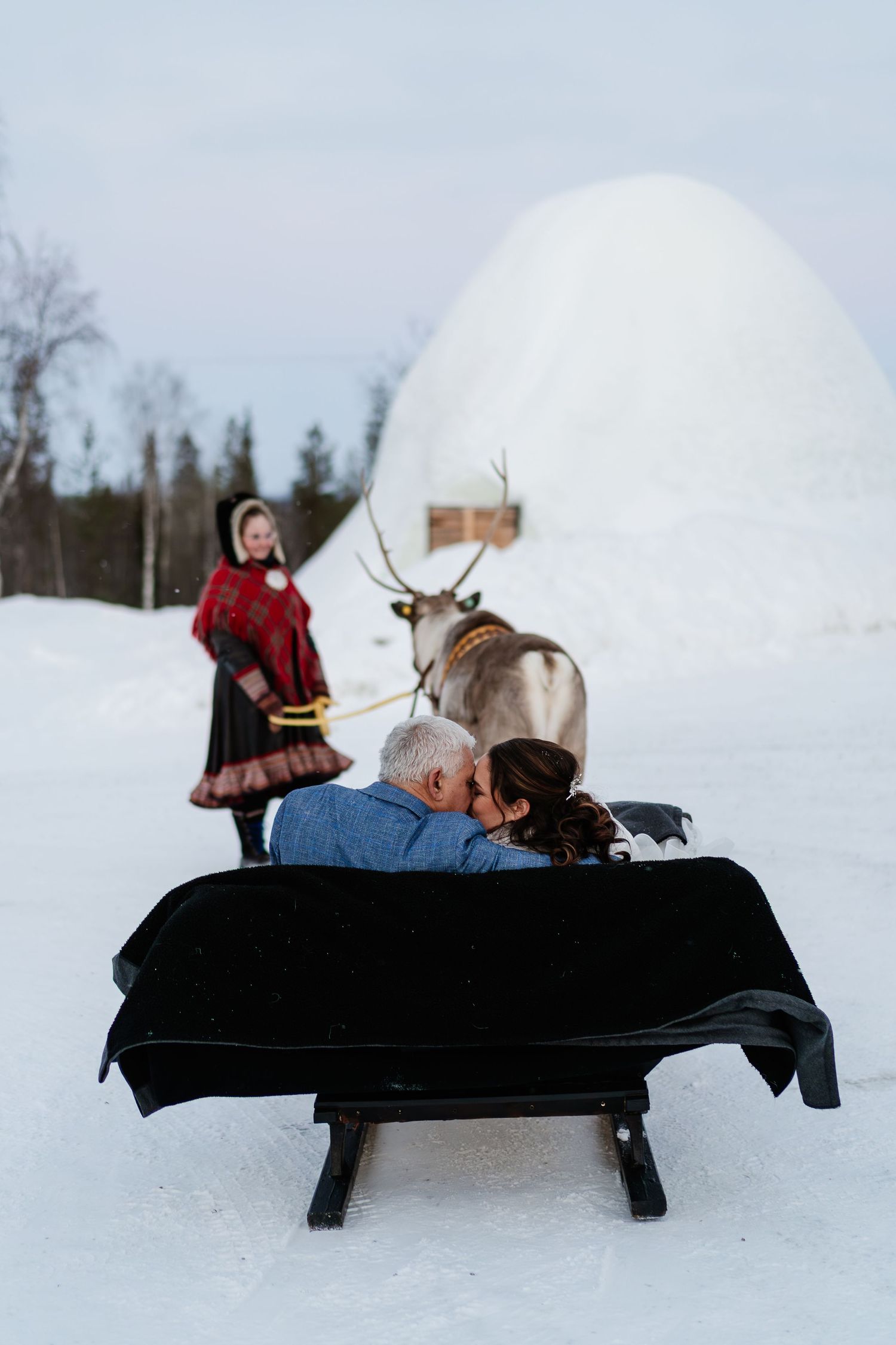Kiss on Reindeer sleigh ride on wedding day in Lapland. Eloping in Lapland. Marry in Lapland. Unique Wedding Experience in Lapland. Photos
