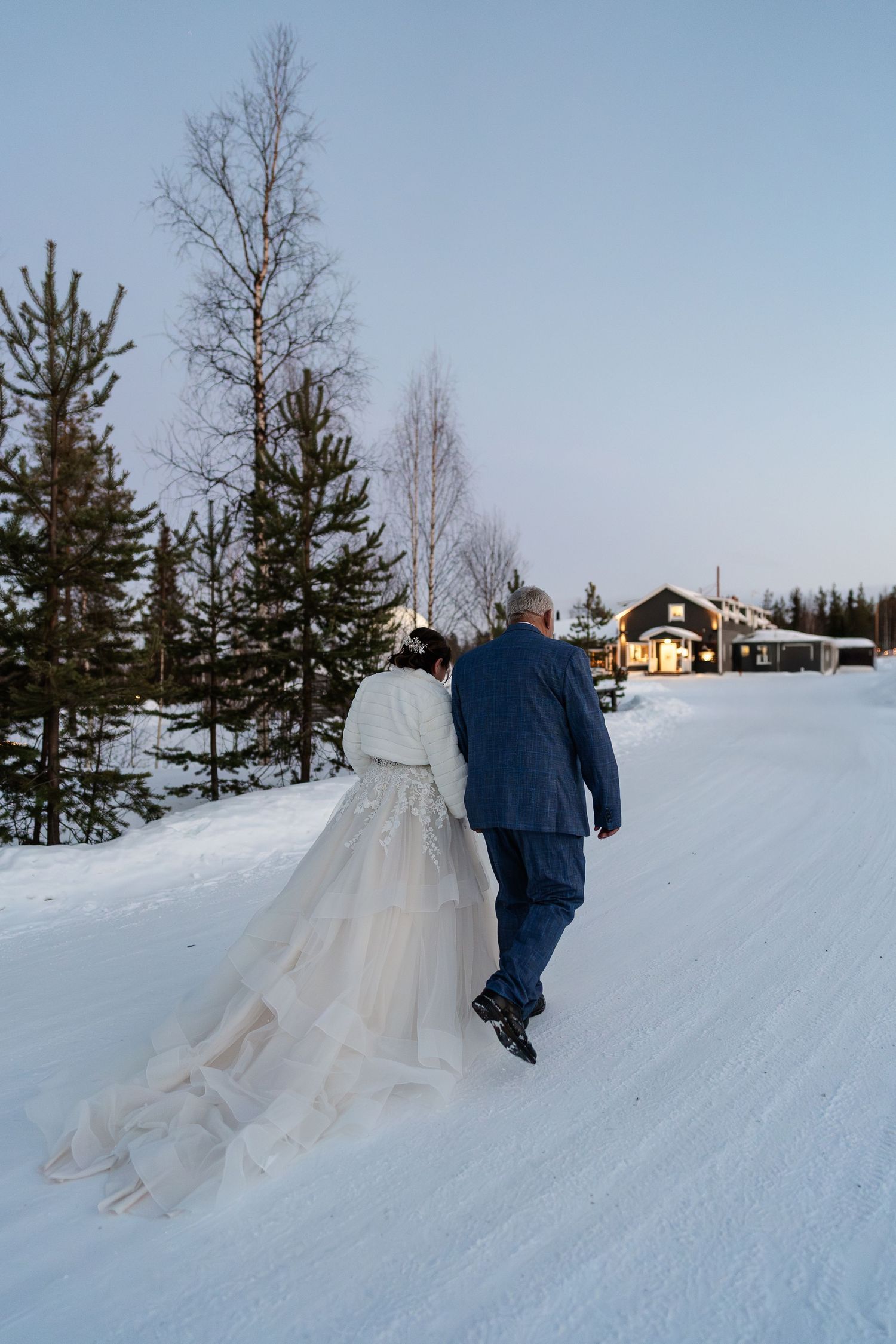 Couple candidly walking through forest with pink skies. Luxury Lapland wedding photographer. Snow wedding. Mountain Wedding. Elegant wedding