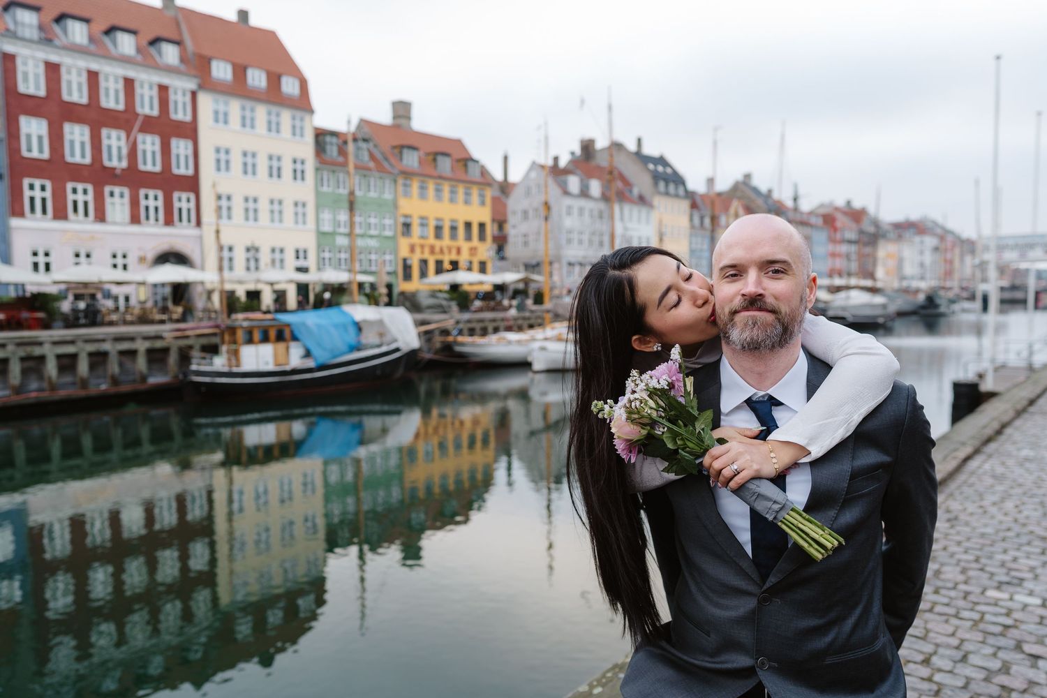 Newlyweds walking along Nyhavn Canal in Copenhagen. Denmark wedding. Scandinavian & Destination Wedding Photographer