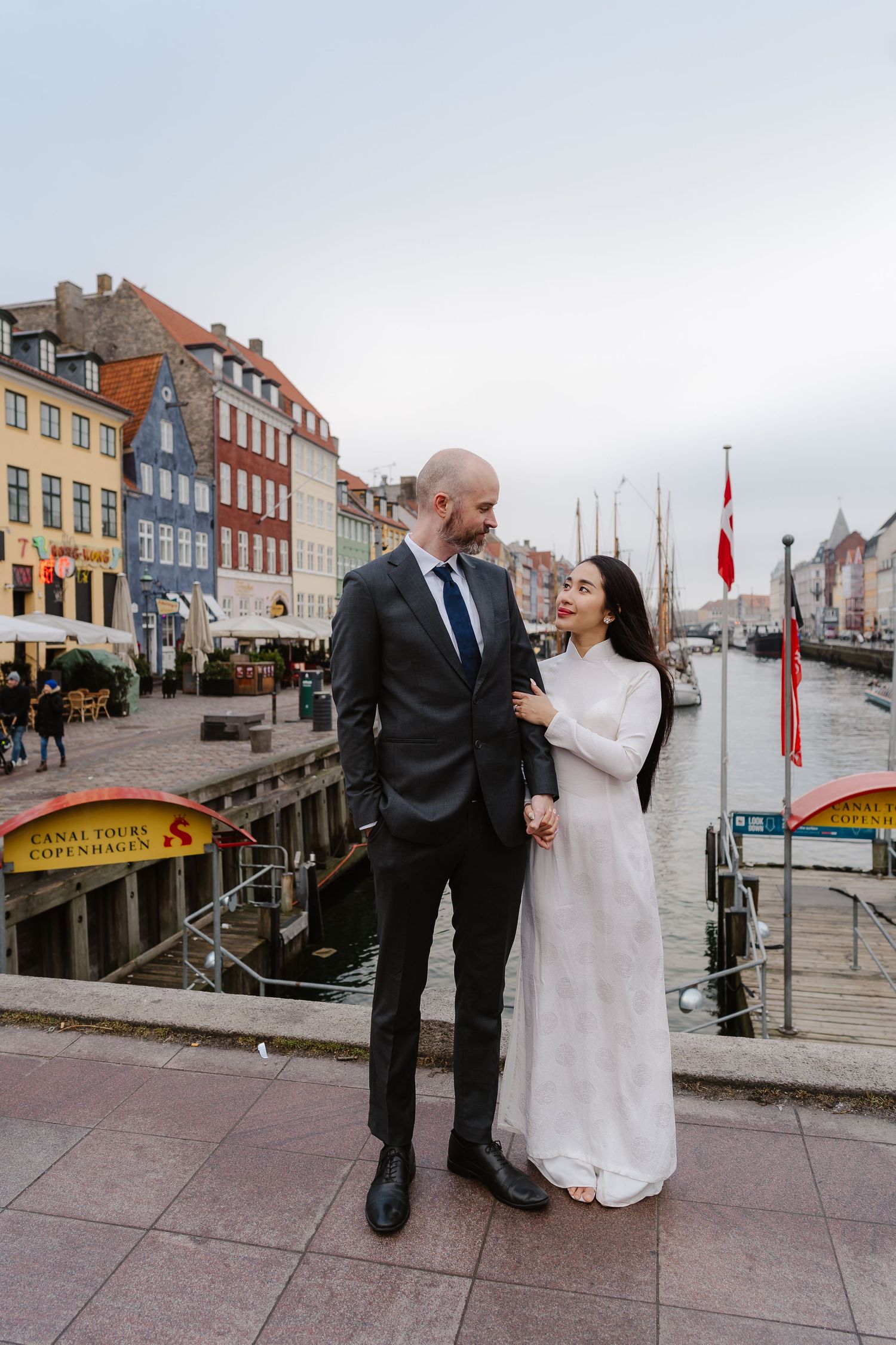 Newlyweds walking along Nyhavn Canal in Copenhagen. Denmark wedding. Scandinavian & Destination Wedding Photographer