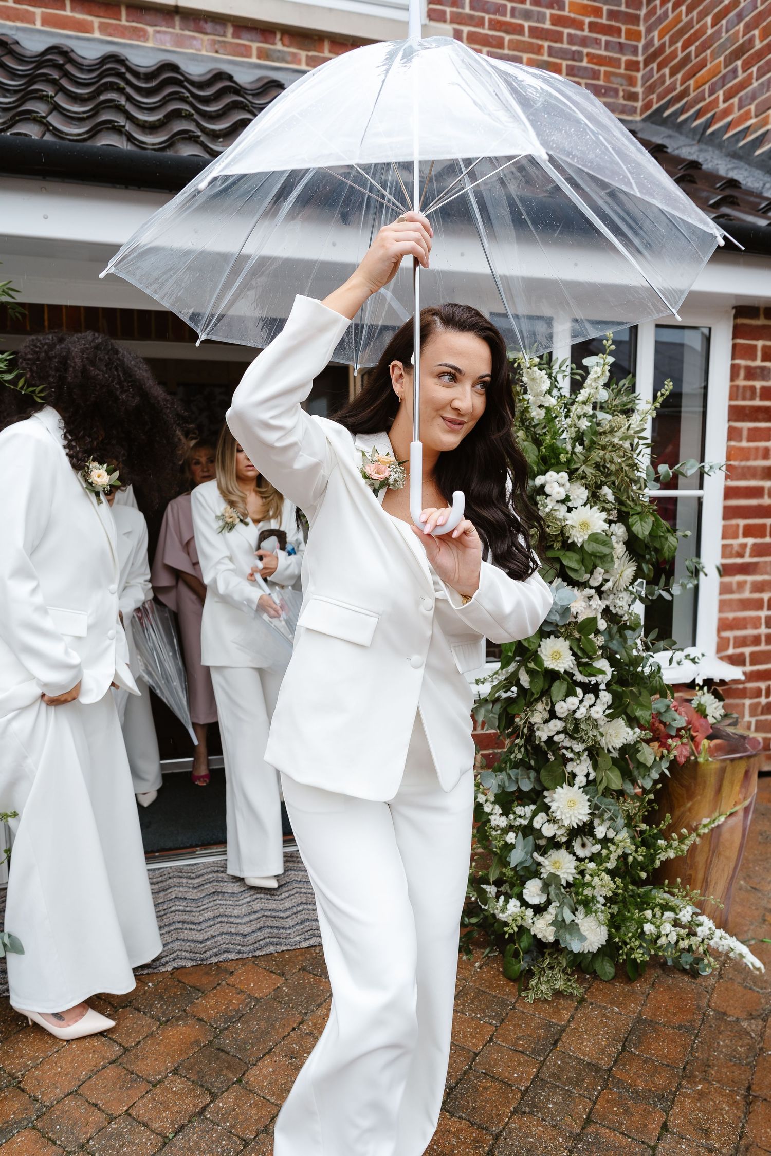 Even the rain couldn't dampen this stylish wedding day/Bridesmaid suits - luxury wedding. Bridesmaids with brollies