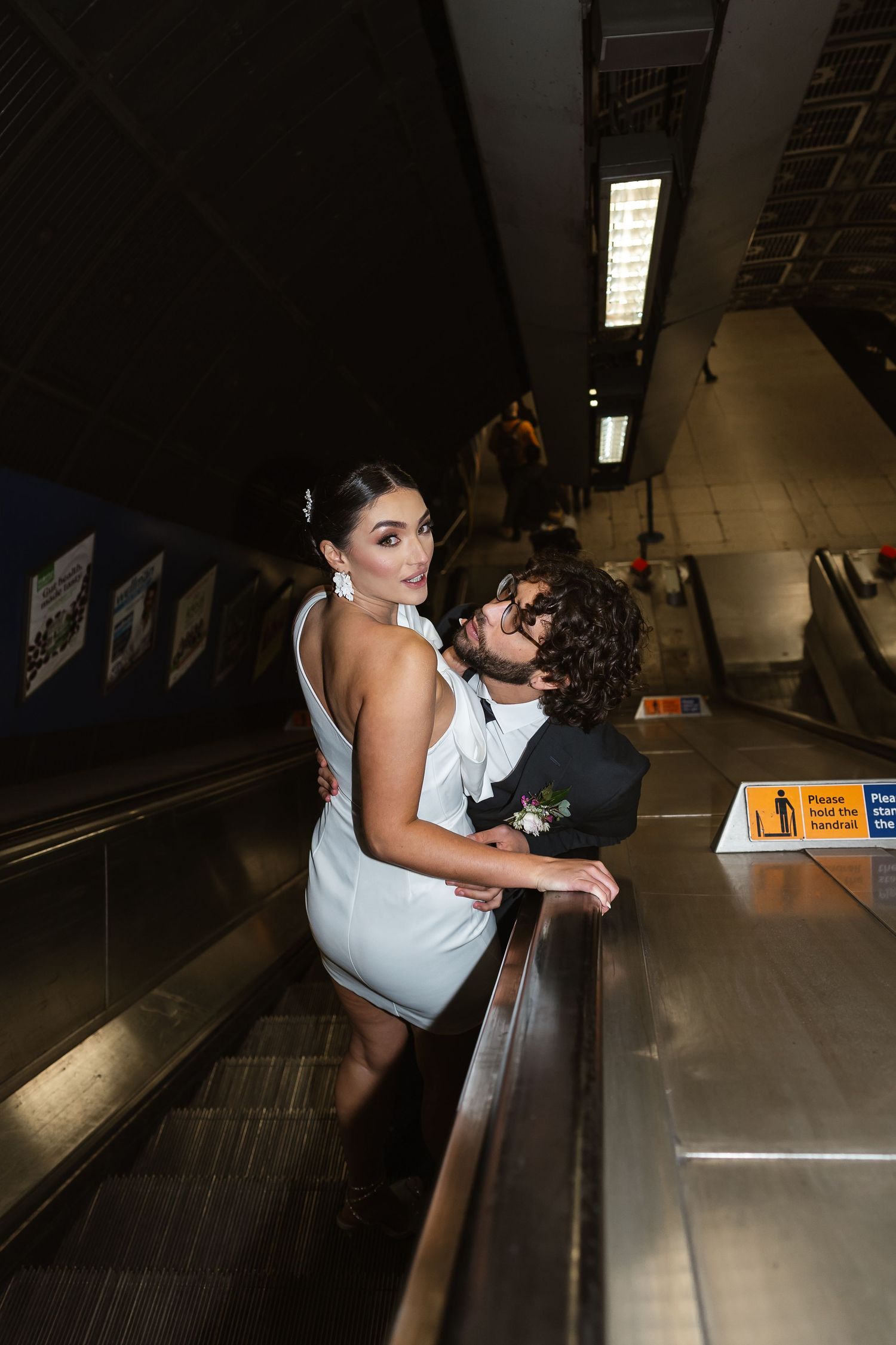 bride and groom in the London Underground Tube, direct flash editorial photography. Modern fun wedding photos. London