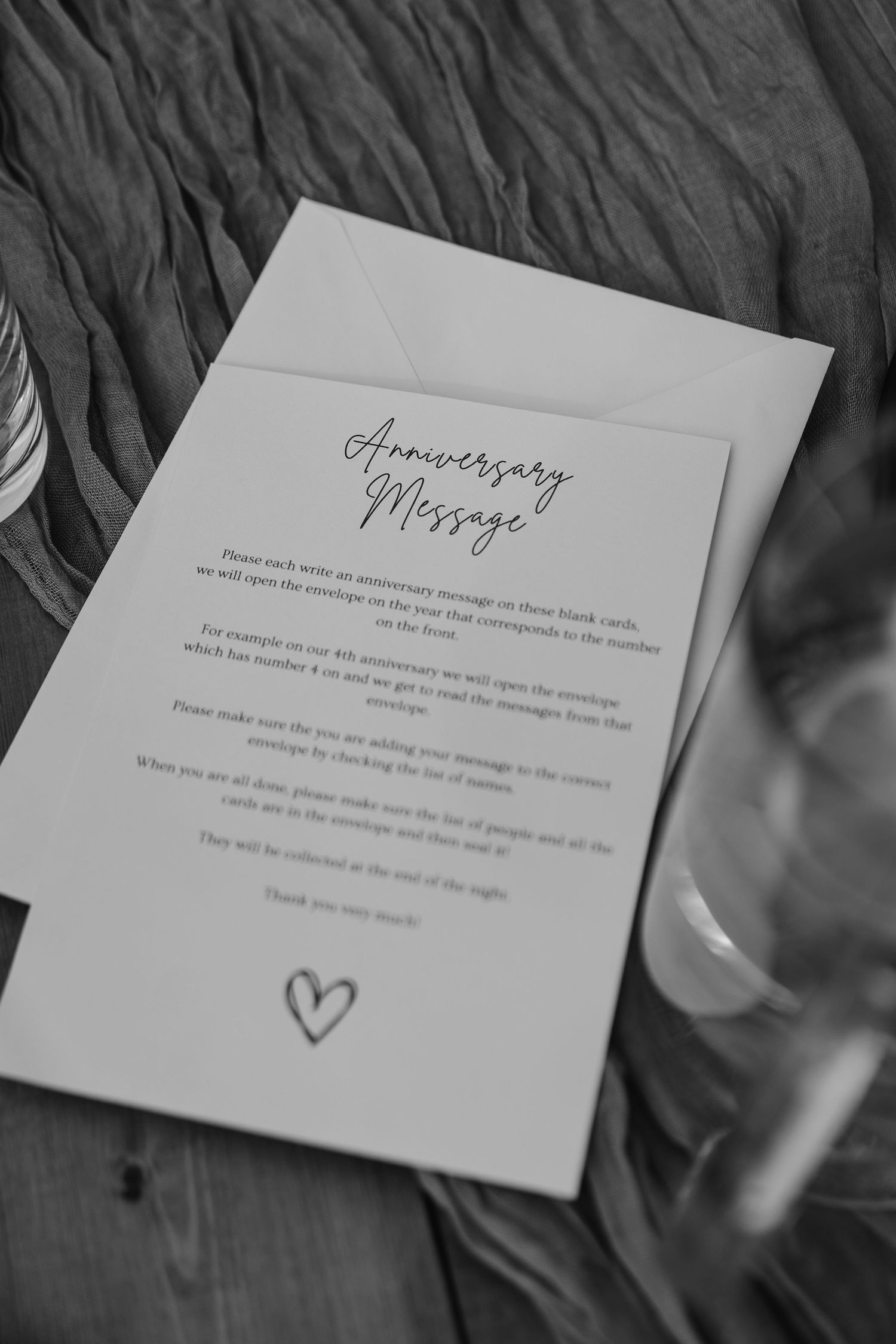 Black and white photo of an elegant anniversary message card at a romantic wedding reception.