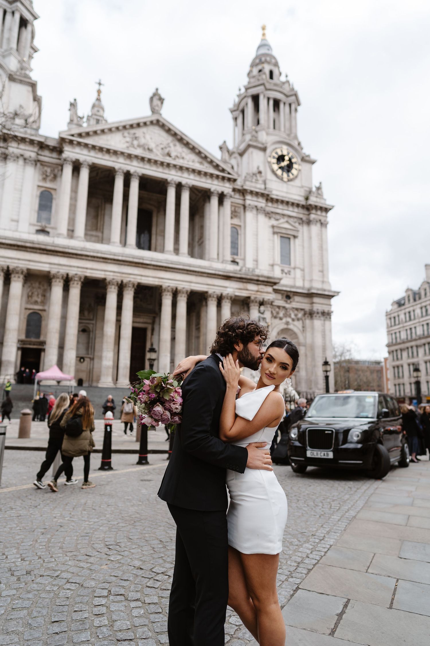 Luxury Bride & Groom walking past St Paul's Cathedral in London on wedding elopement. Wedding photographer