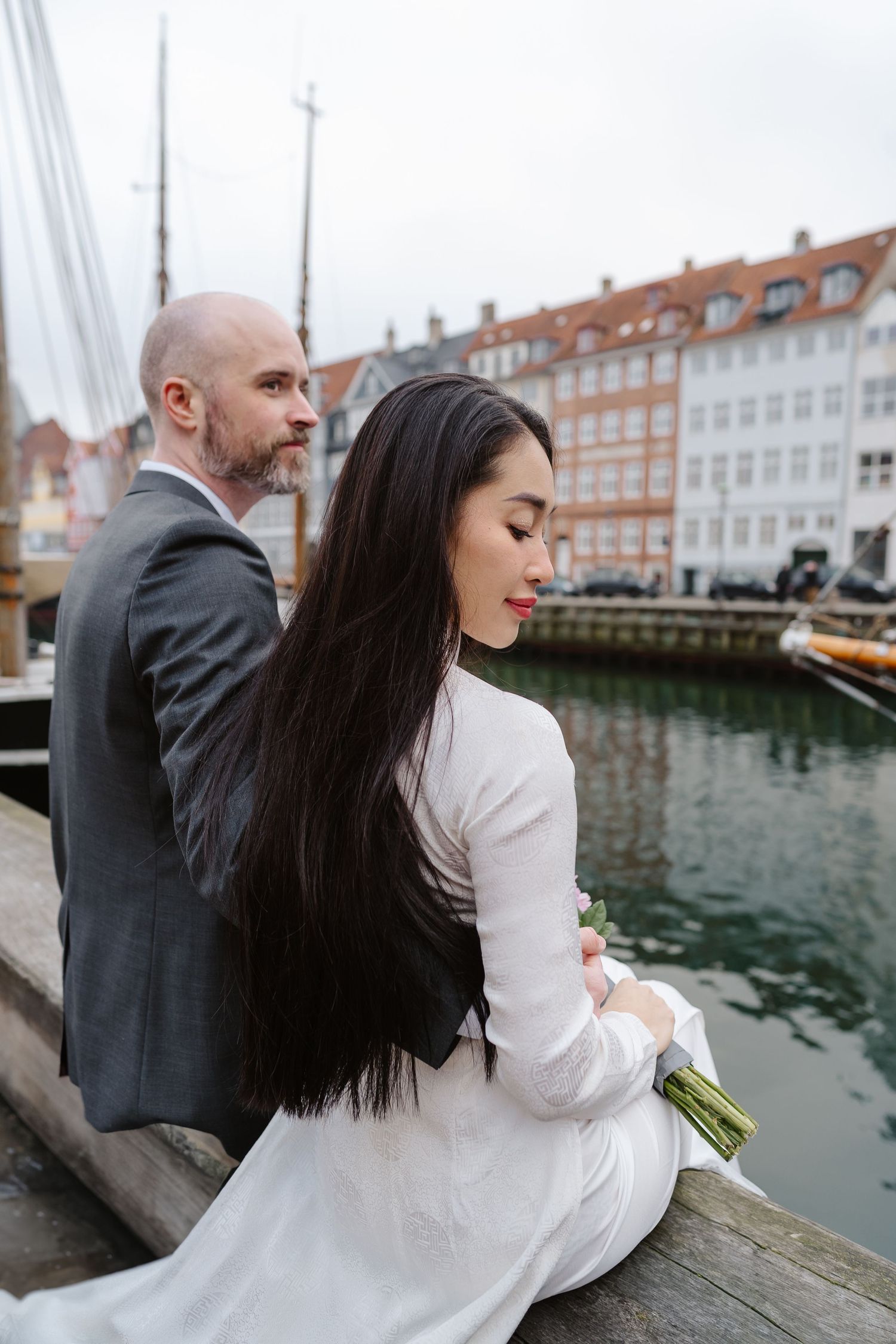 Newlyweds walking along Nyhavn Canal in Copenhagen. Denmark wedding. Scandinavian & Destination Wedding Photographer