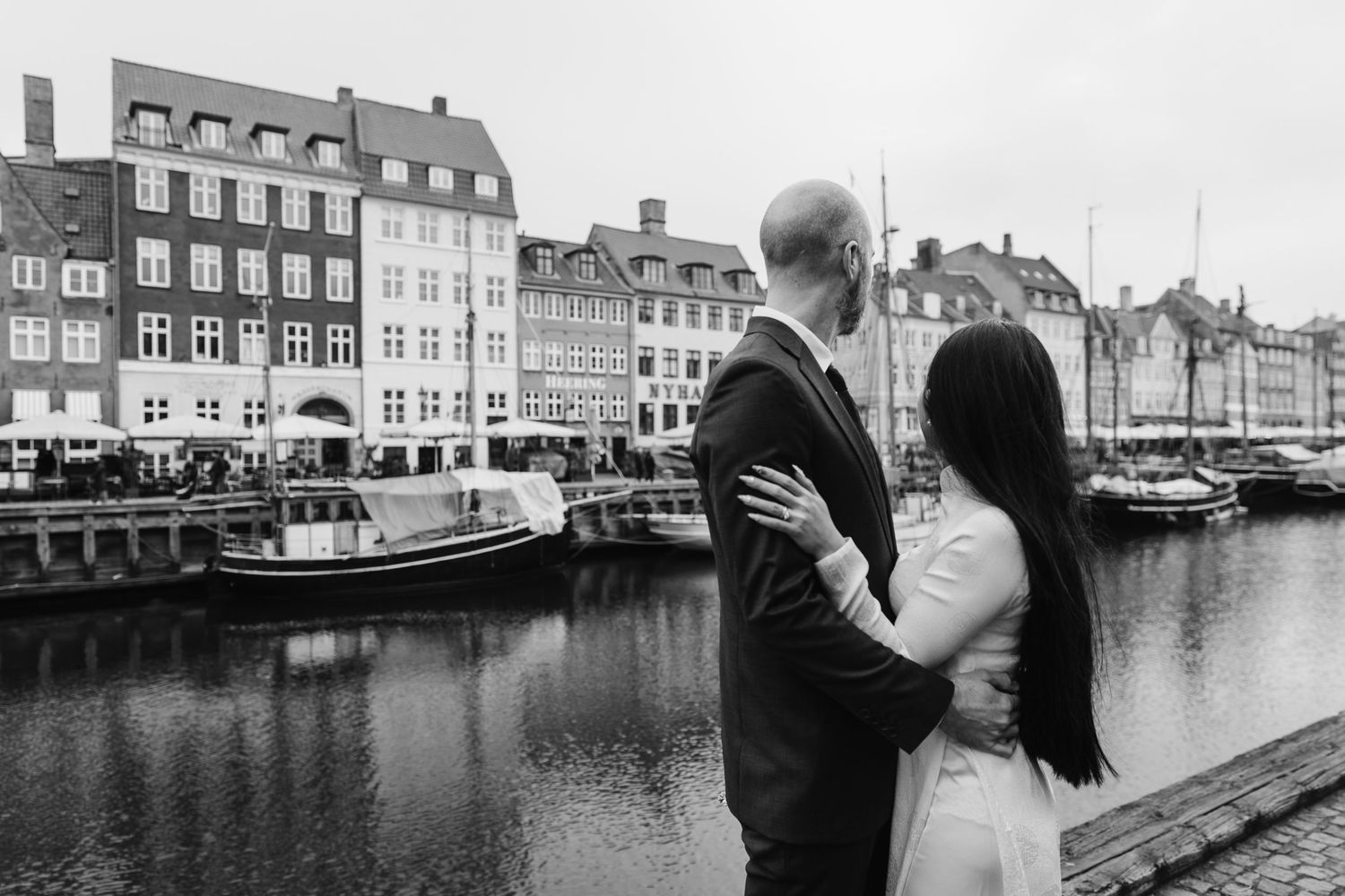Newlyweds walking along Nyhavn Canal in Copenhagen. Denmark wedding. Scandinavian & Destination Wedding Photographer
