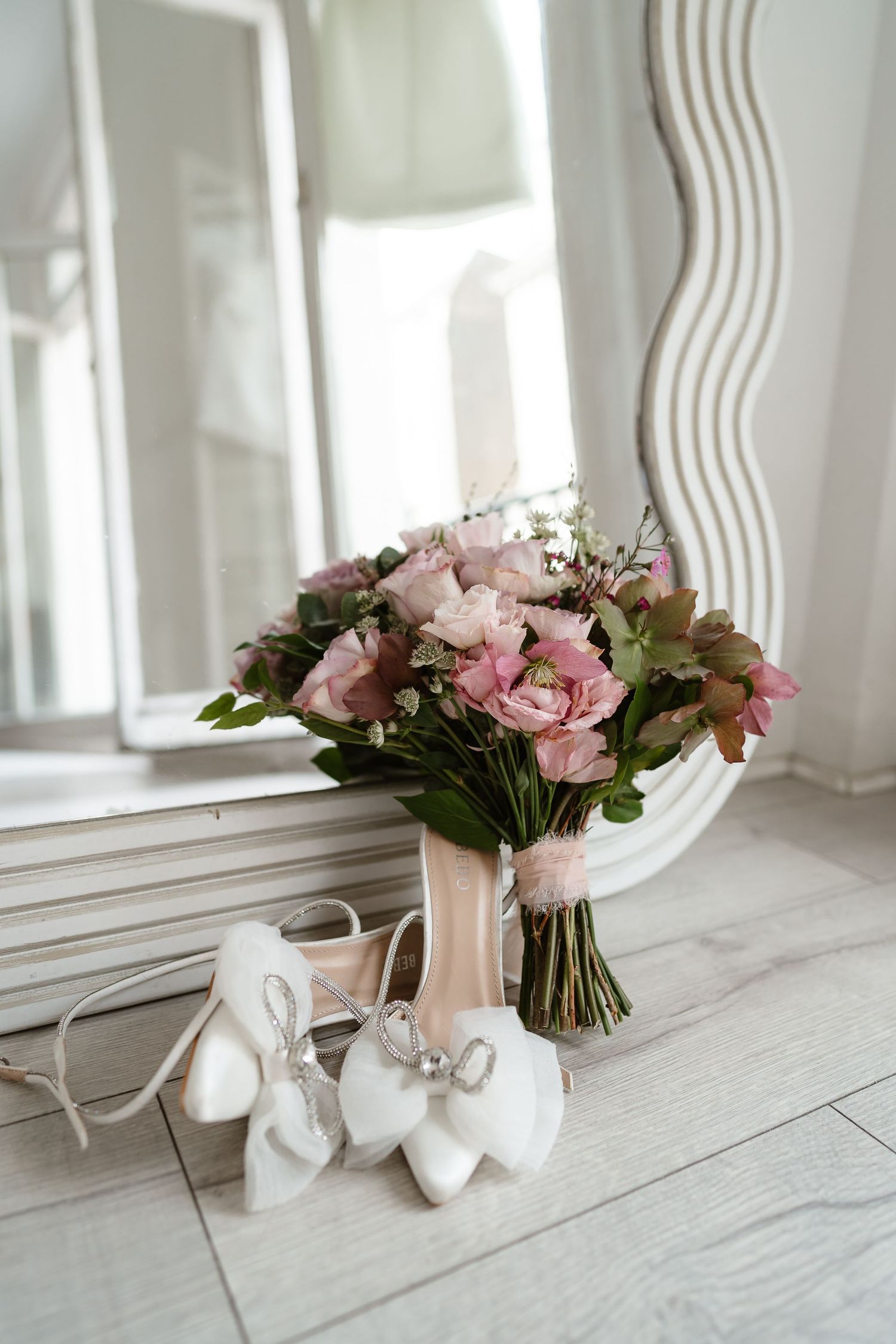 Wedding details. Dusky pink flowers bouquet and bridal shoes. London St Paul's for London Weddin