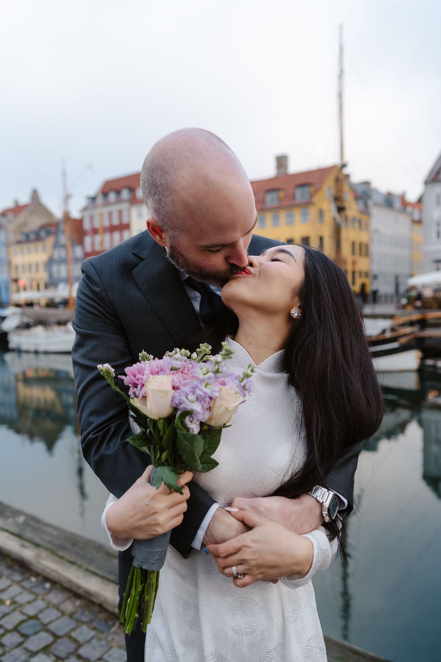 Newlyweds walking along Nyhavn Canal in Copenhagen. Denmark wedding. Scandinavian & Destination Wedding Photographer