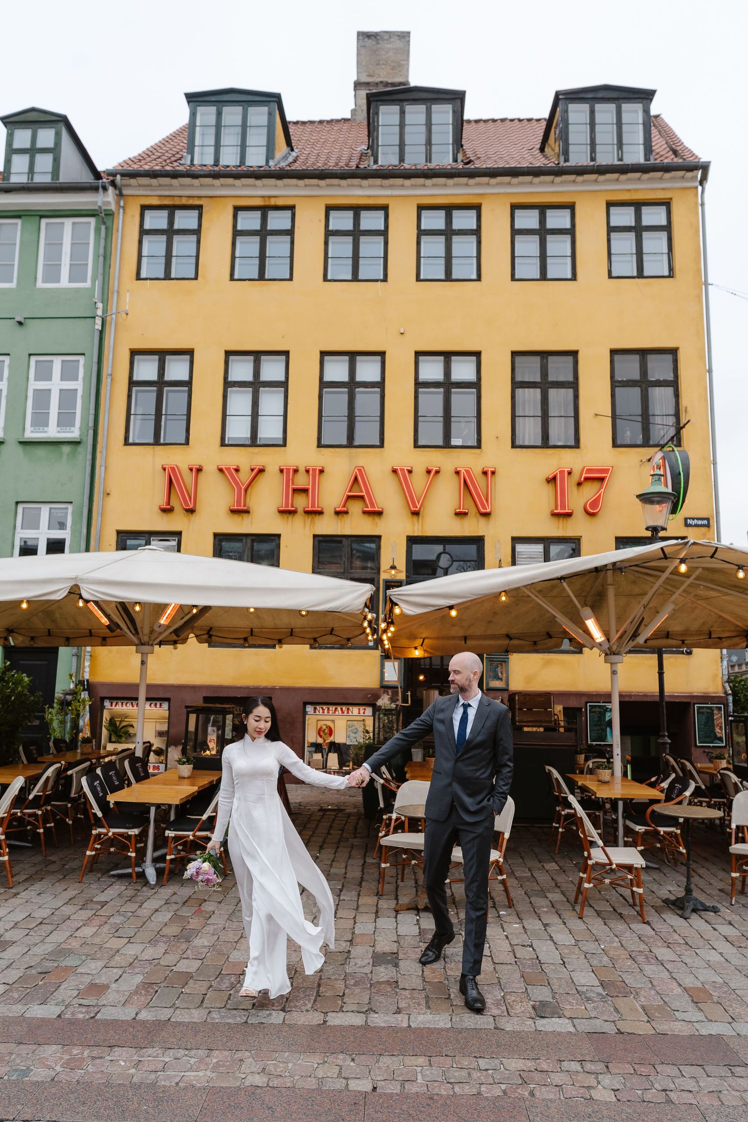 Newlyweds walking along Nyhavn Canal in Copenhagen. Denmark wedding. Scandinavian & Destination Wedding Photographer