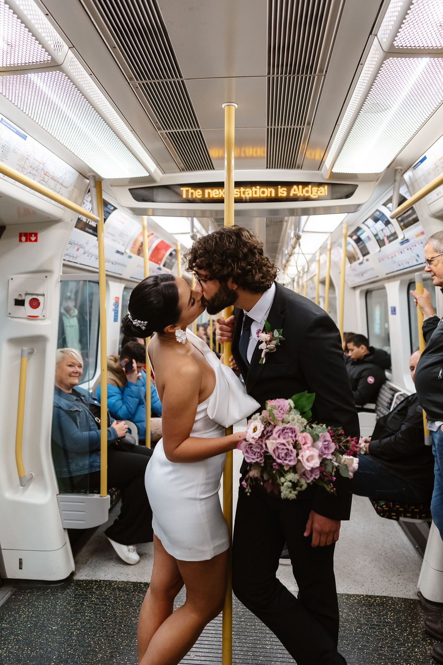 Bride and groom on London Underground tube wedding photos. Taken by London Wedding Photographer