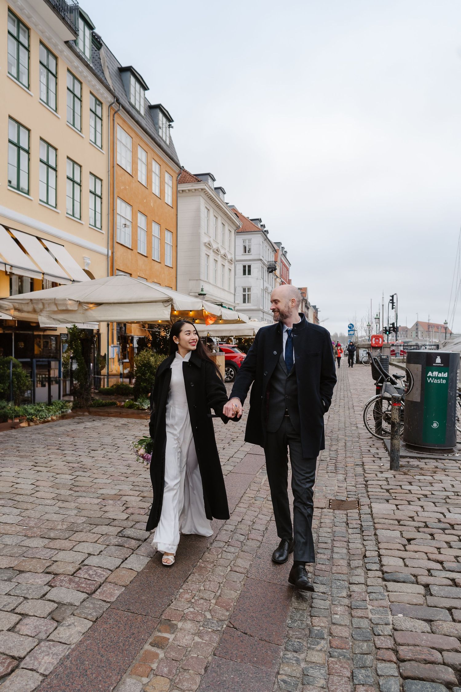 Newlyweds walking along Nyhavn Canal in Copenhagen. Denmark wedding. Scandinavian & Destination Wedding Photographer