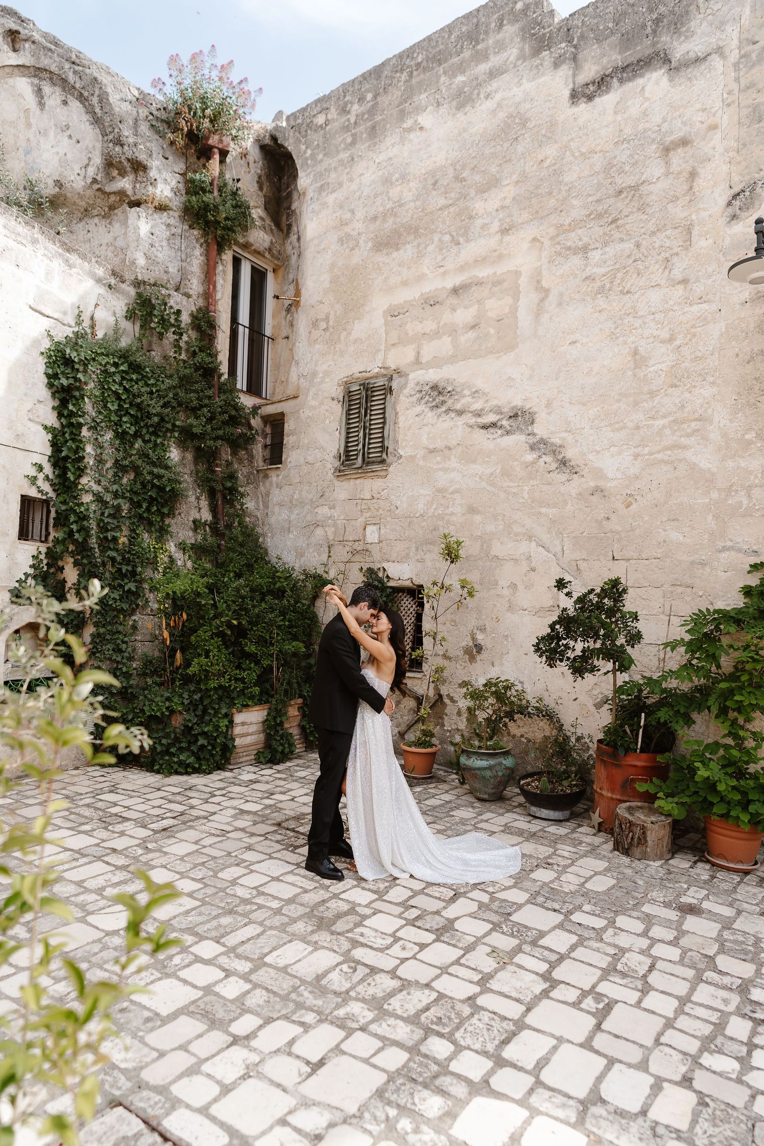 loving embrace - beautiful colourful courtyard intimate moment. Puglia wedding photographer