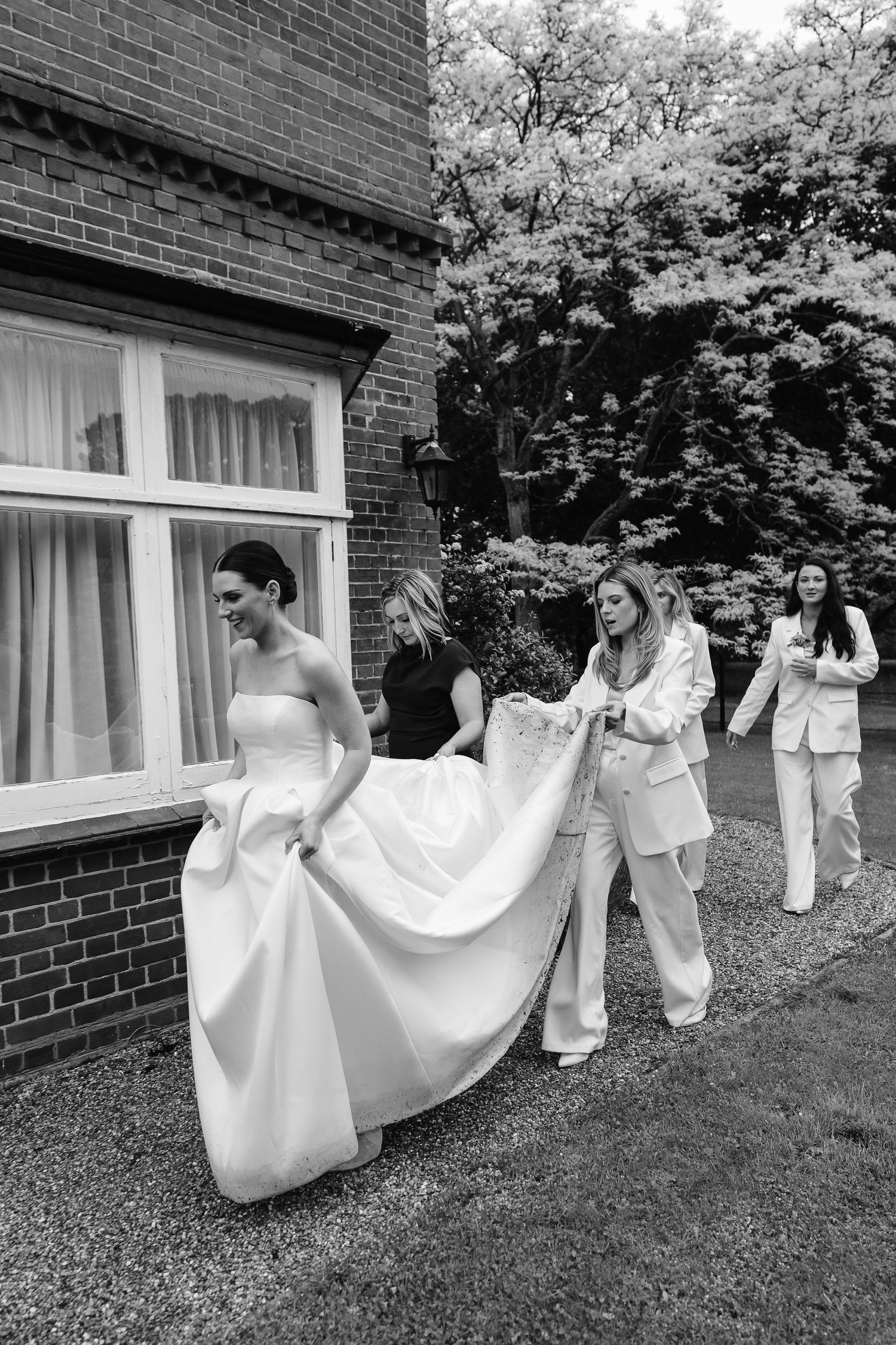 Helping hand with wet train on the Vera Wang wedding dress / Uk & Norfolk wedding photographer