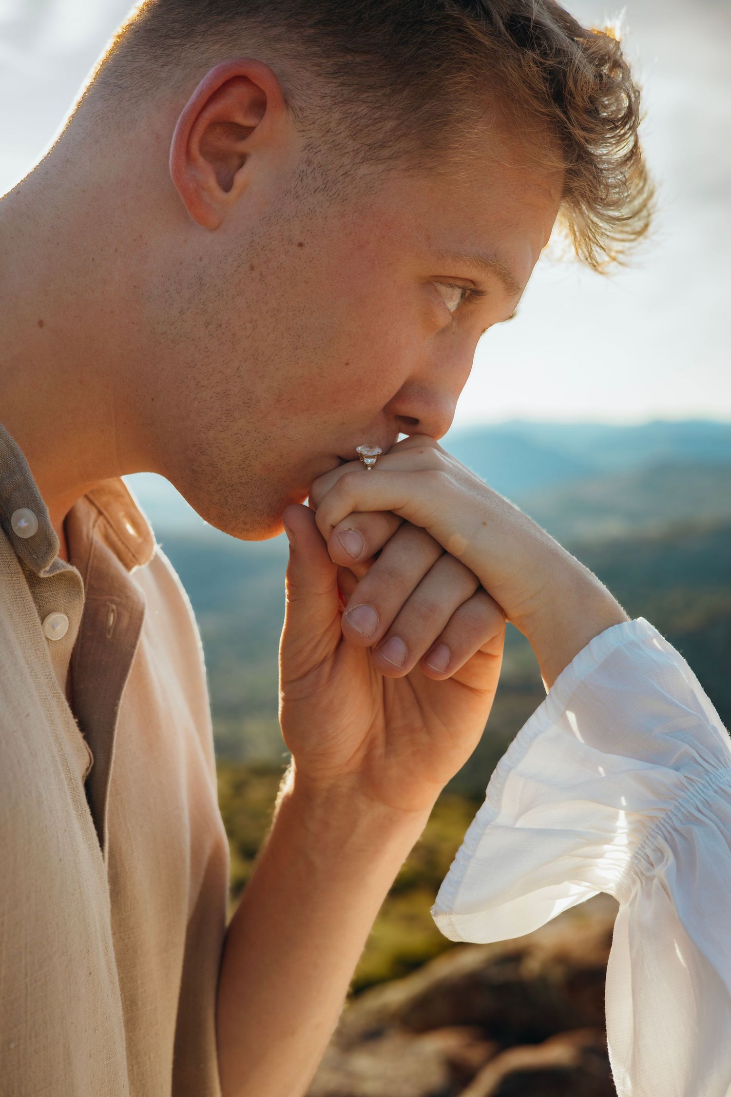 A tender moment as hands are brought together against a mountain vista.