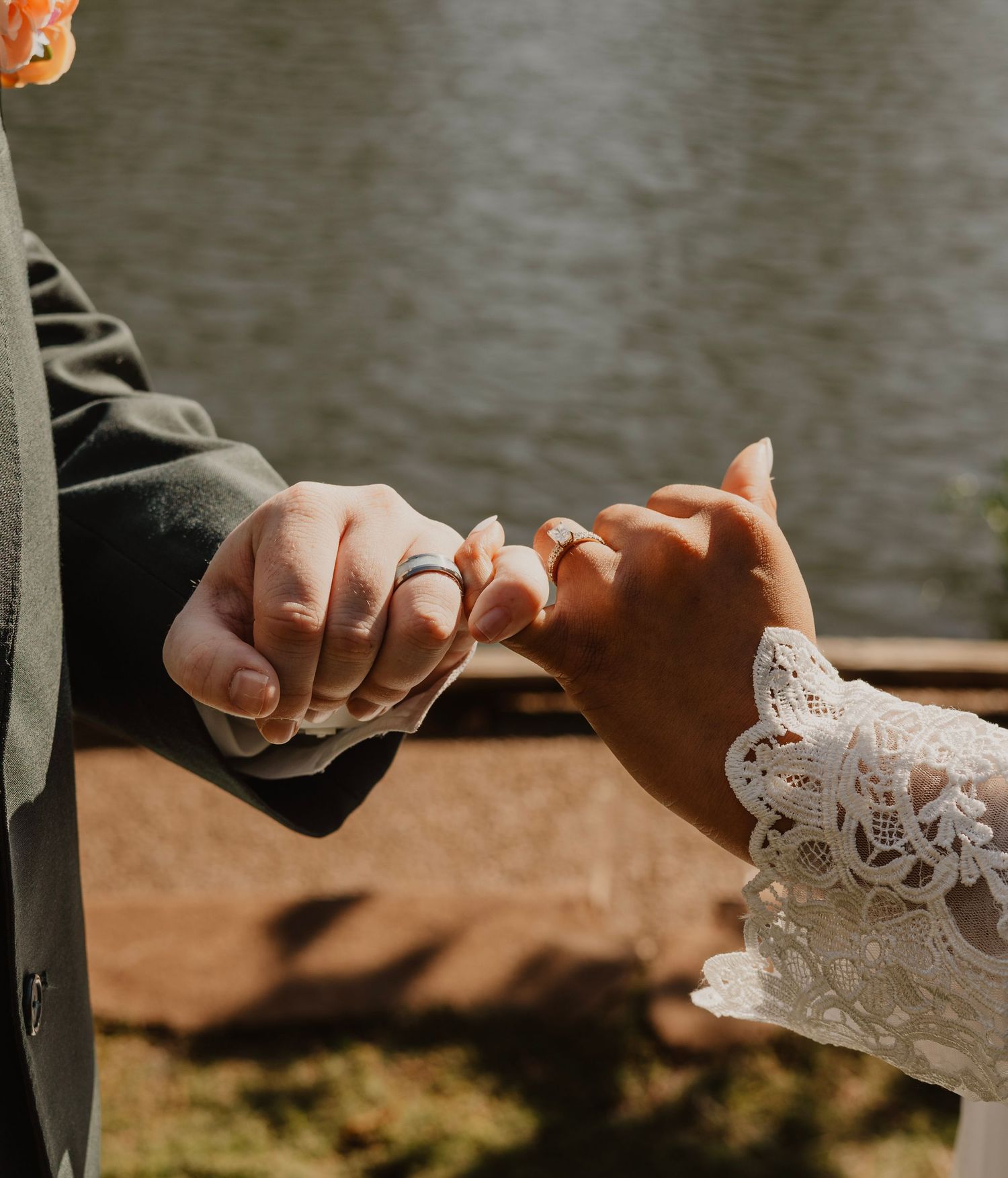 Close-up of hands touching delicate lace wedding dress detail.